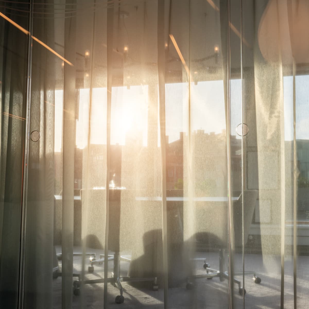 Solen skiner genom de skira gardinerna.