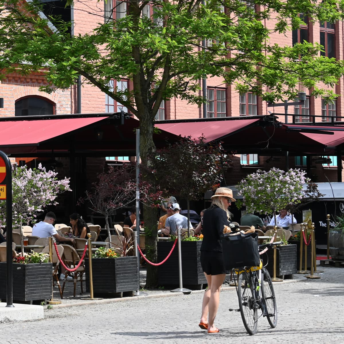 En kvinna går längs en gata bredvid en hög byggnad.