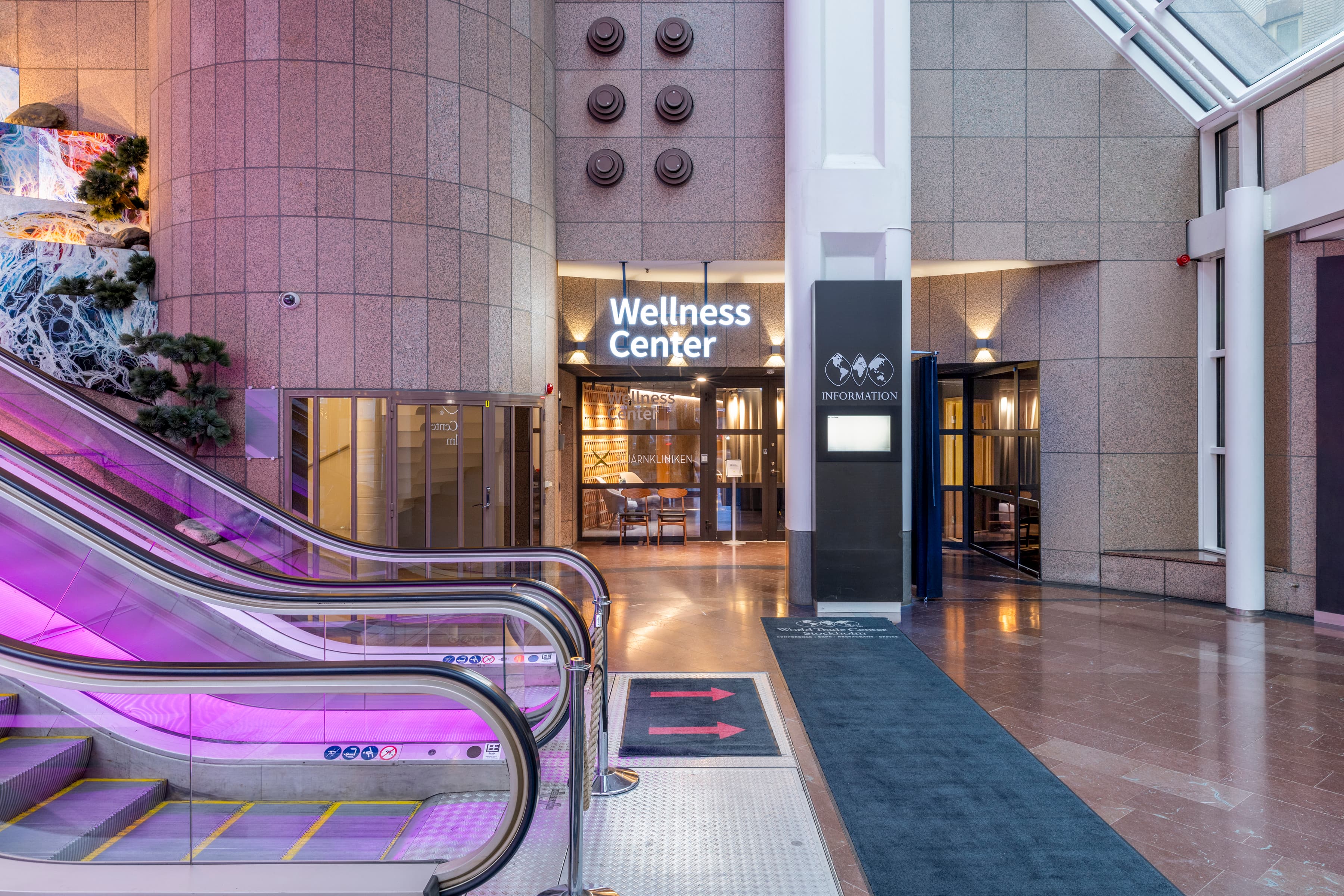 En rulltrappa i en byggnad med ett lila ljus.