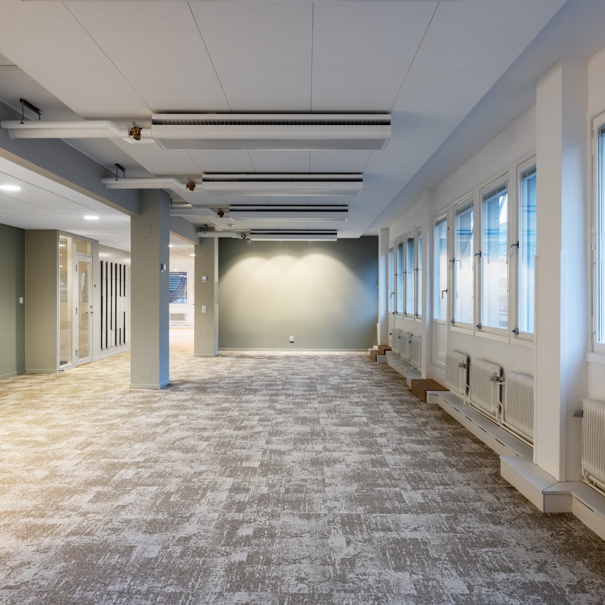 Ett stort tomt rum med många fönster.