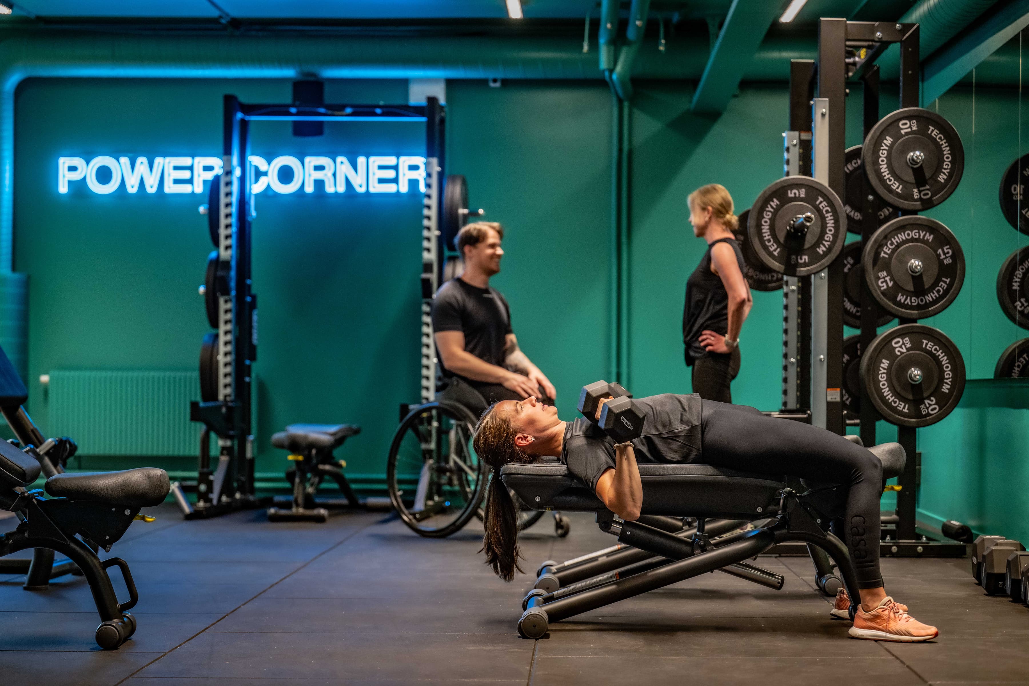 En man utför bänkpress på ett gym.