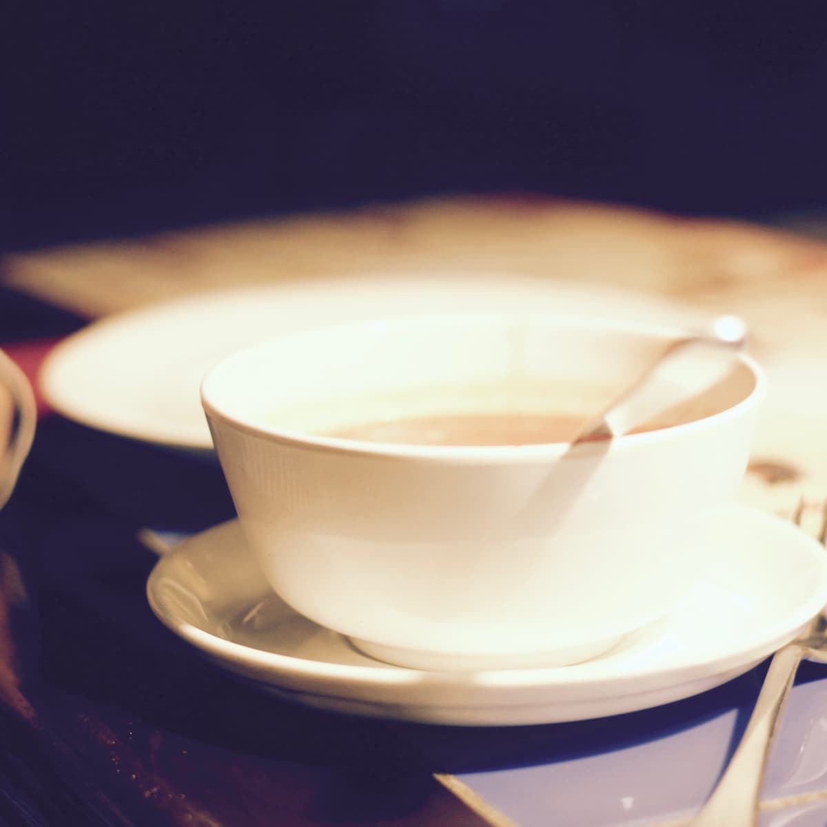 En kopp kaffe som står på ett vitt fat.