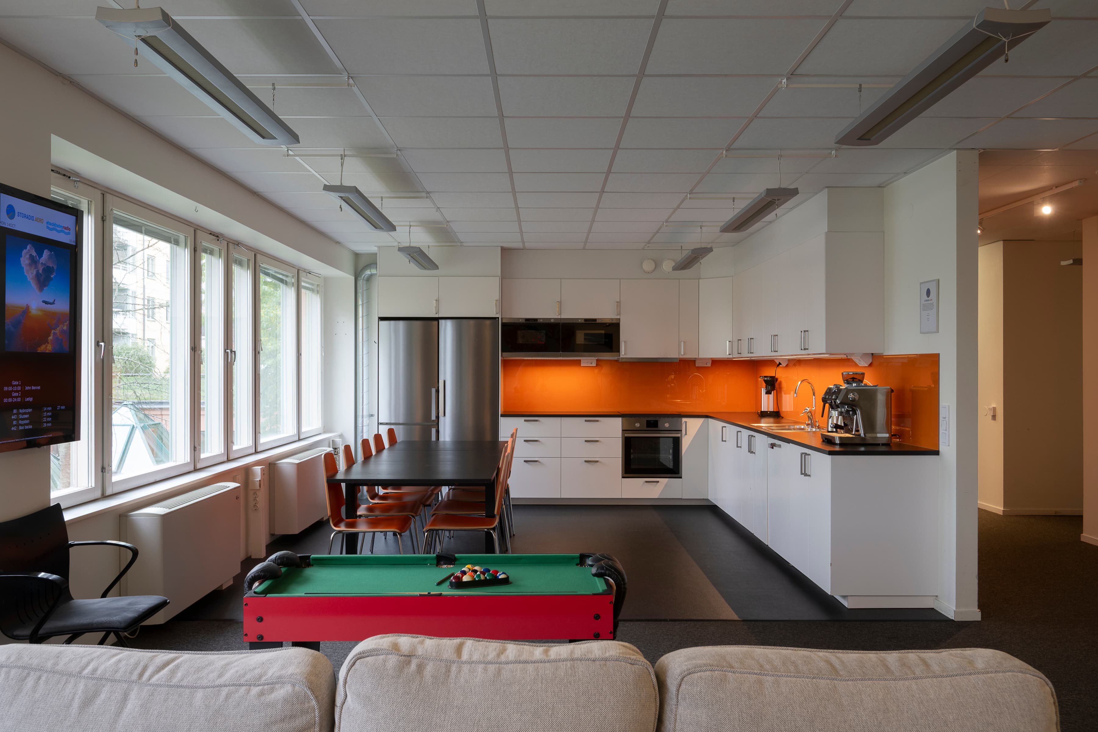 Ett vardagsrum med biljardbord och platt-tv.