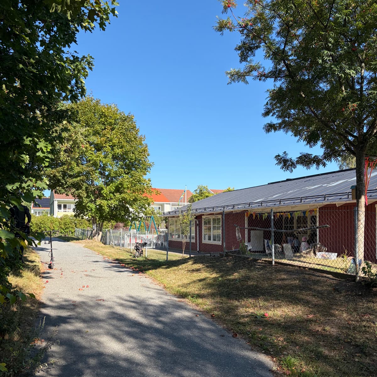 En röd byggnad som ligger intill en frodig grön skog.