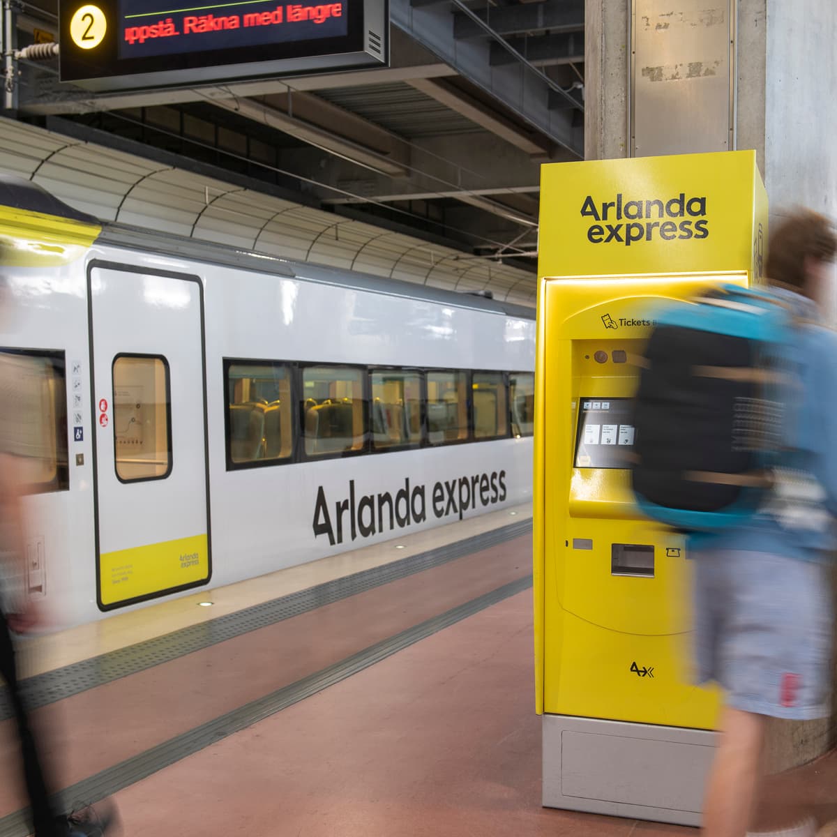 En grupp människor som står bredvid ett tåg på en tågstation.