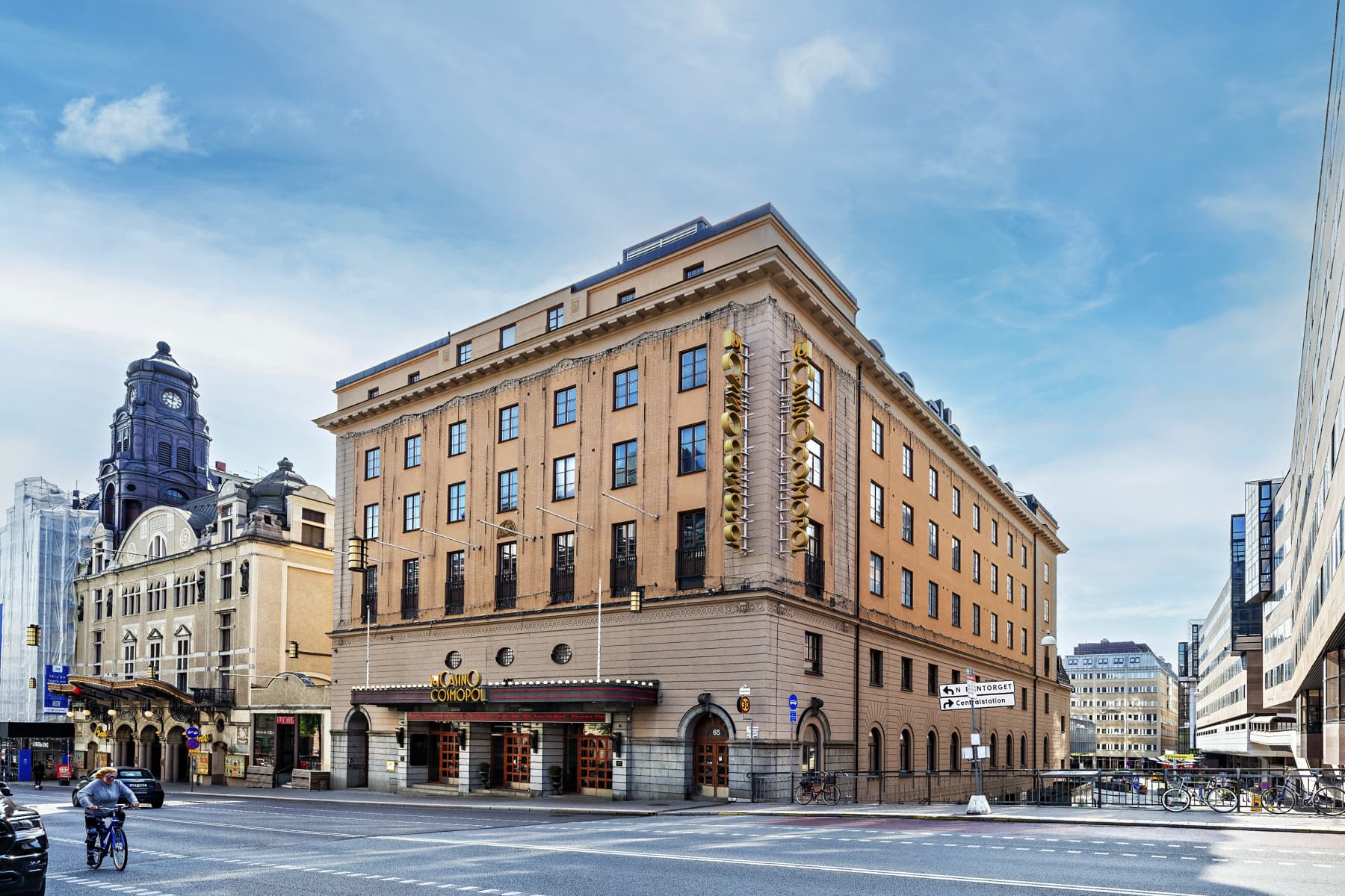En stor brun byggnad som ligger i hörnet av en gata.