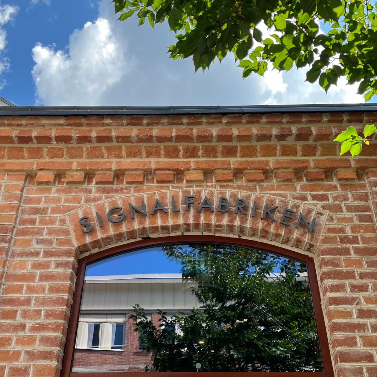 En tegelbyggnad med ett stort välvt fönster.