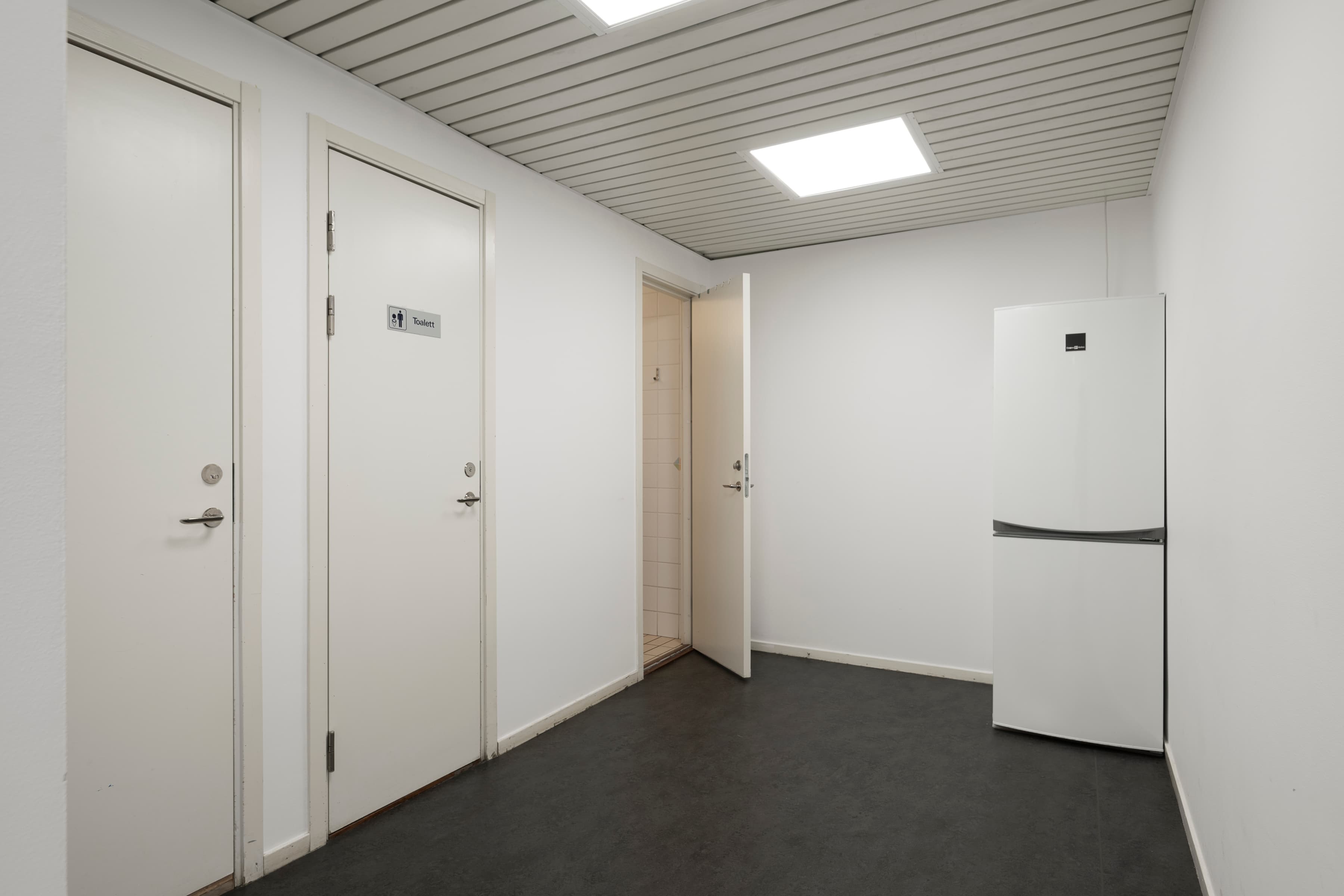 Ett tomt rum med ett kylskåp och en kylfrys.