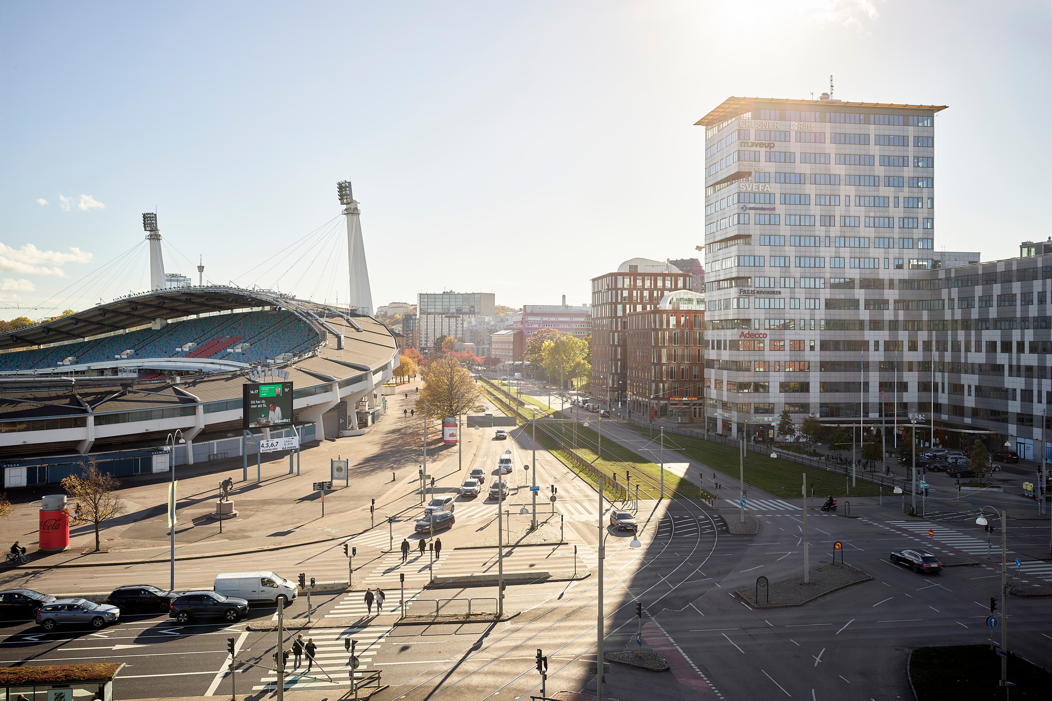 Solen skiner över en gata i en stad.