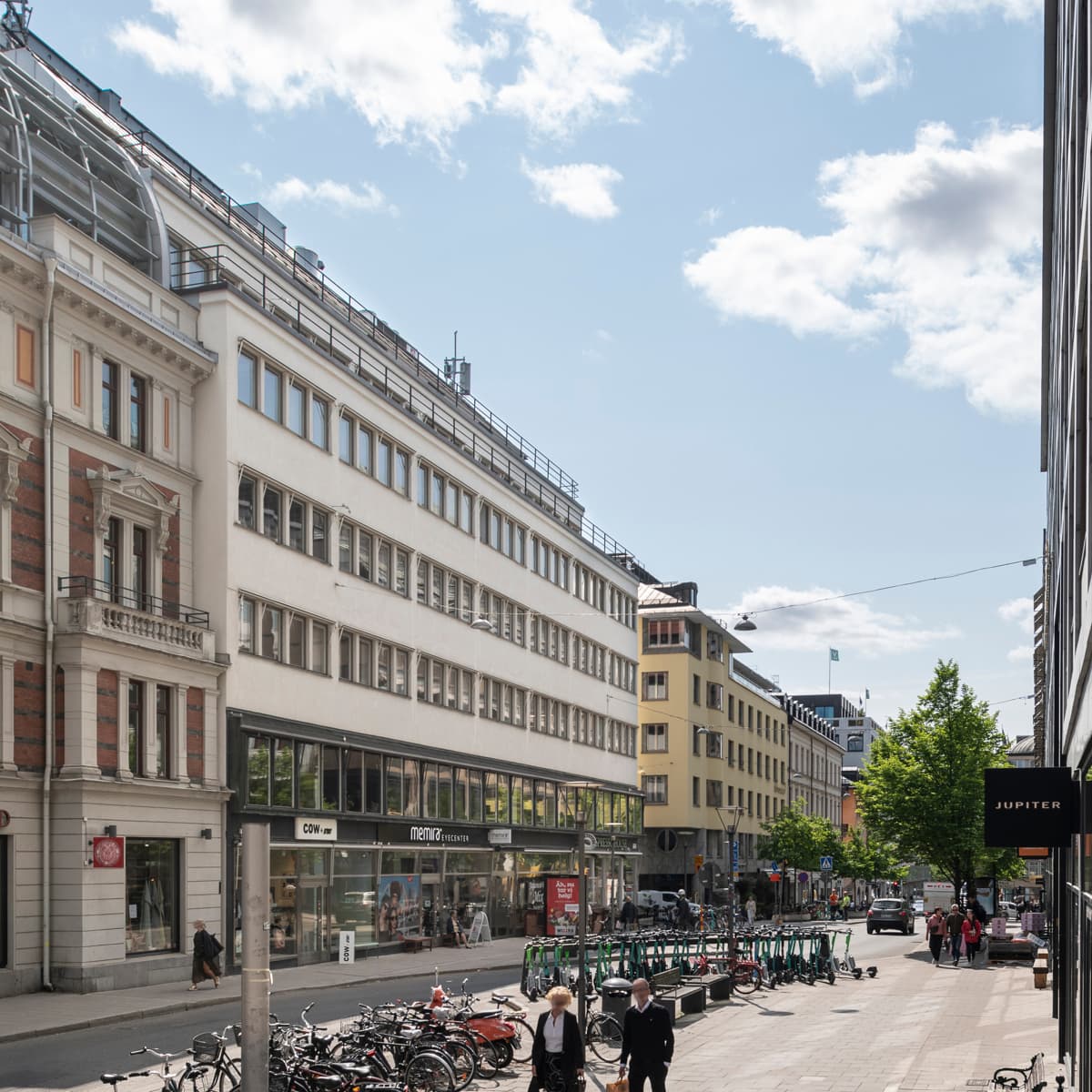 En stadsgata kantad av höga byggnader och parkerade cyklar.