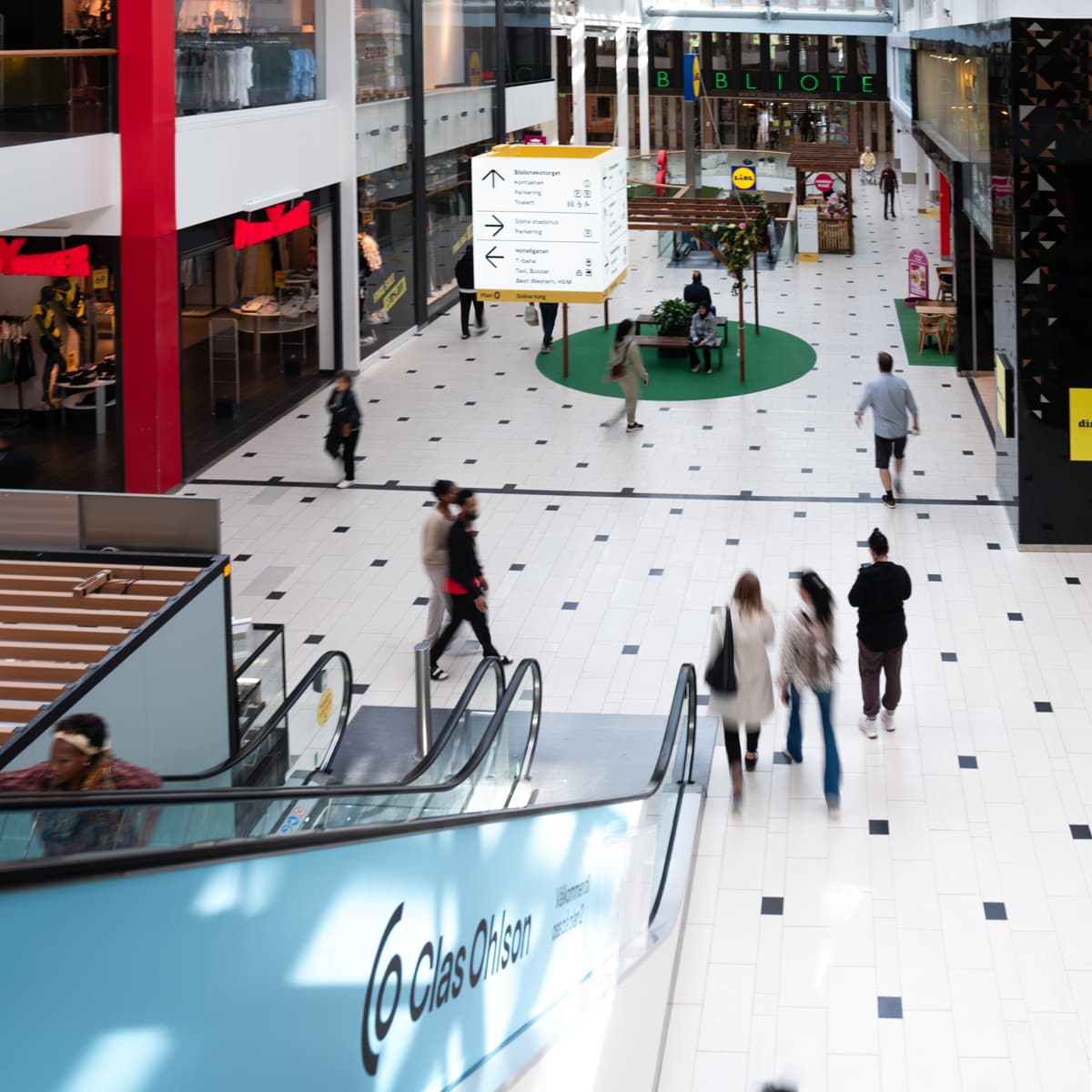 En grupp människor som går genom ett köpcentrum.