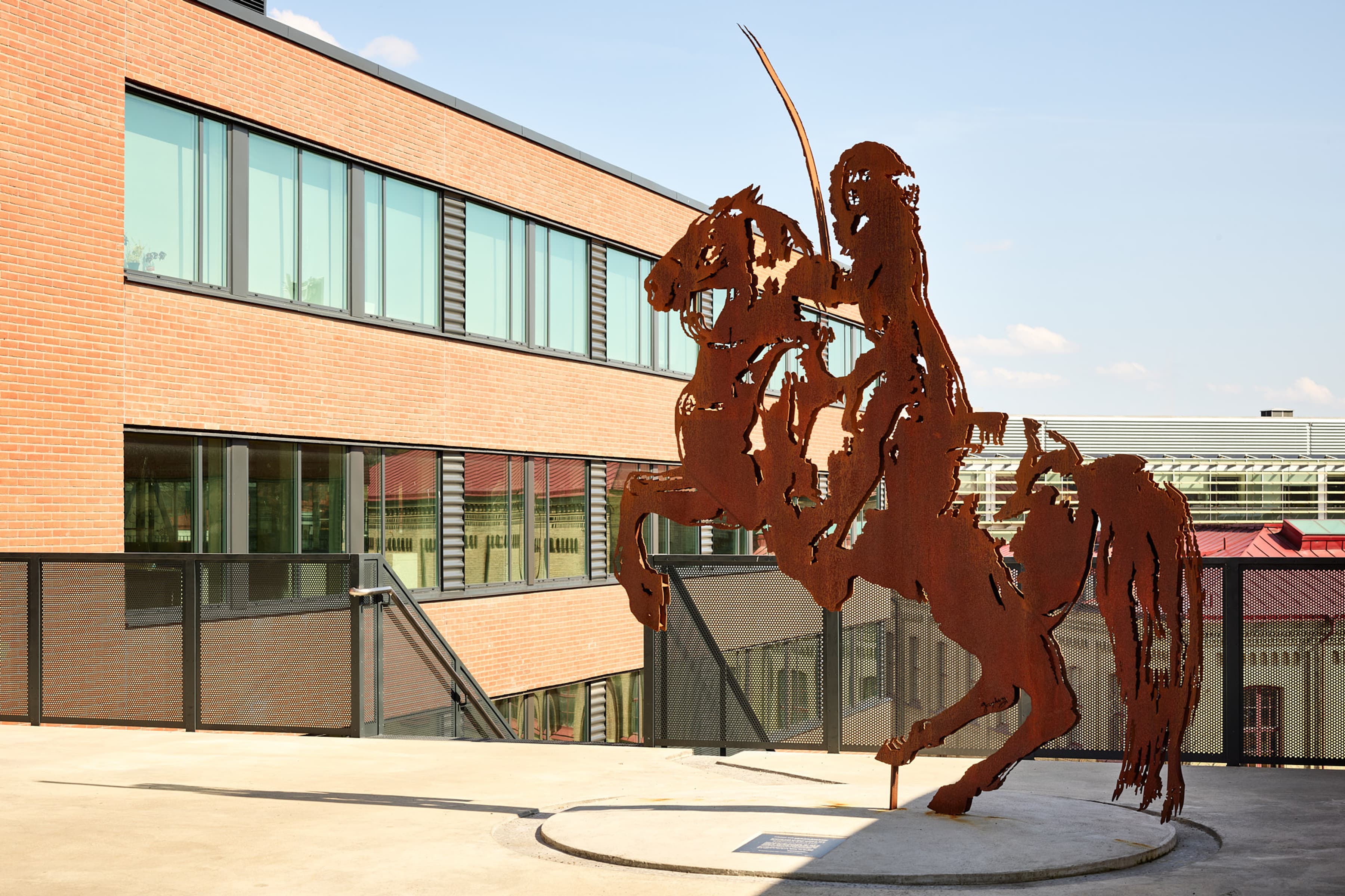 En staty av en man på en häst framför en byggnad.