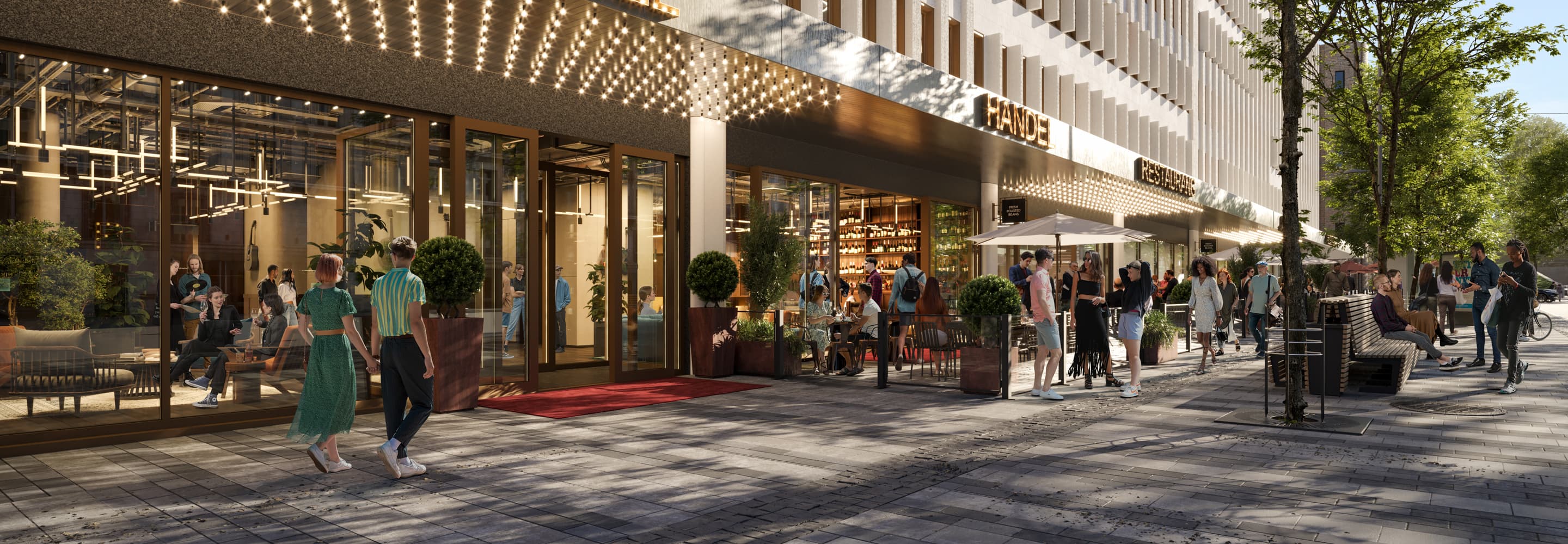 En grupp människor som går längs en gata bredvid en hög byggnad.