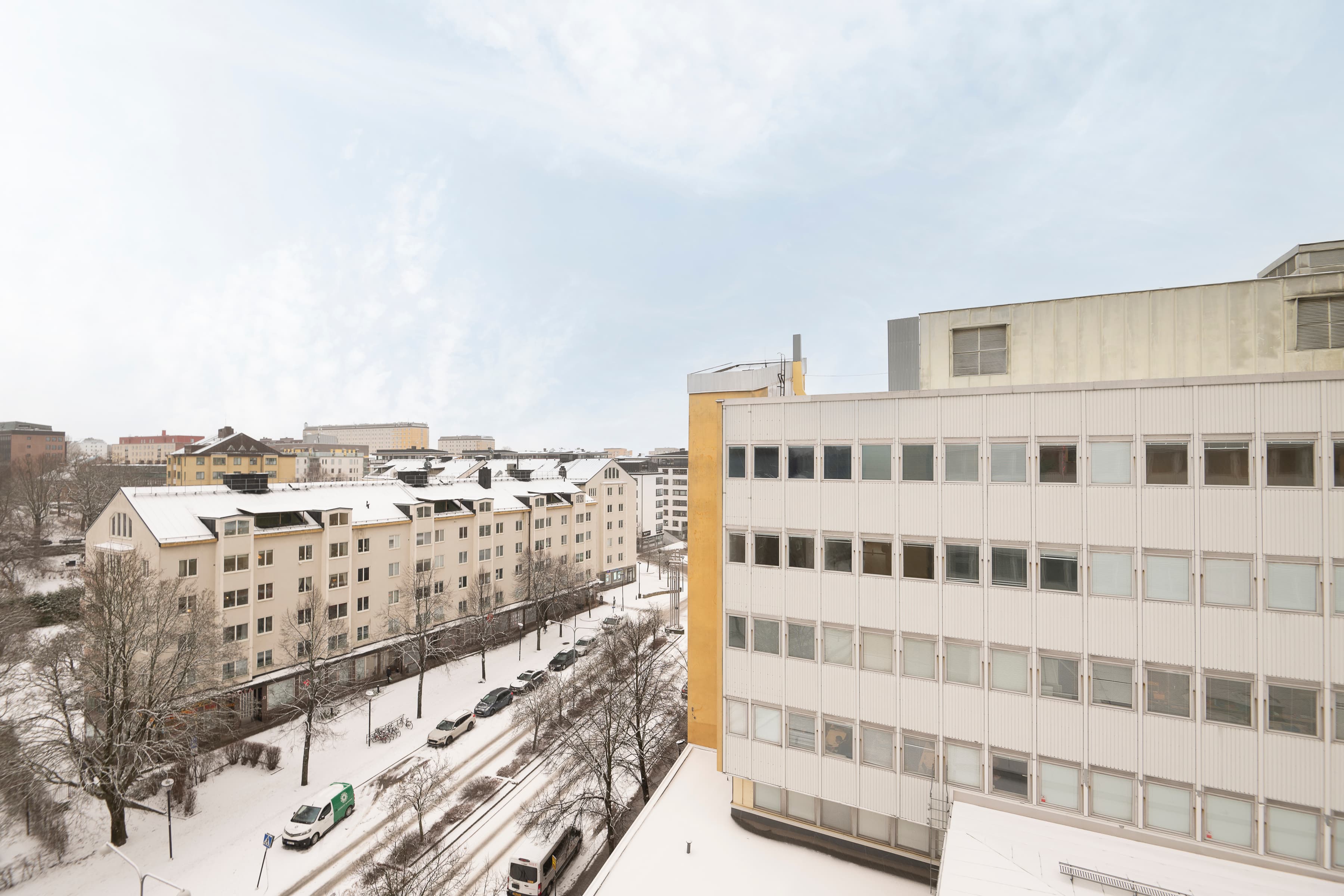 En utsikt över en snöig stad från ett fönster.