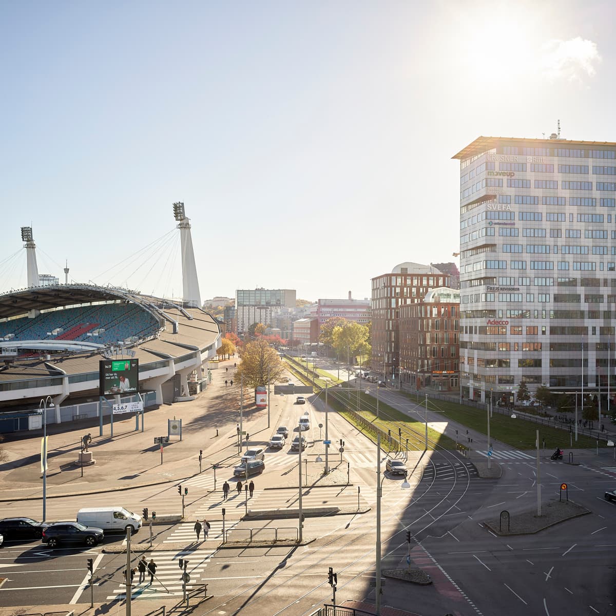Solen skiner över en gata i en stad.