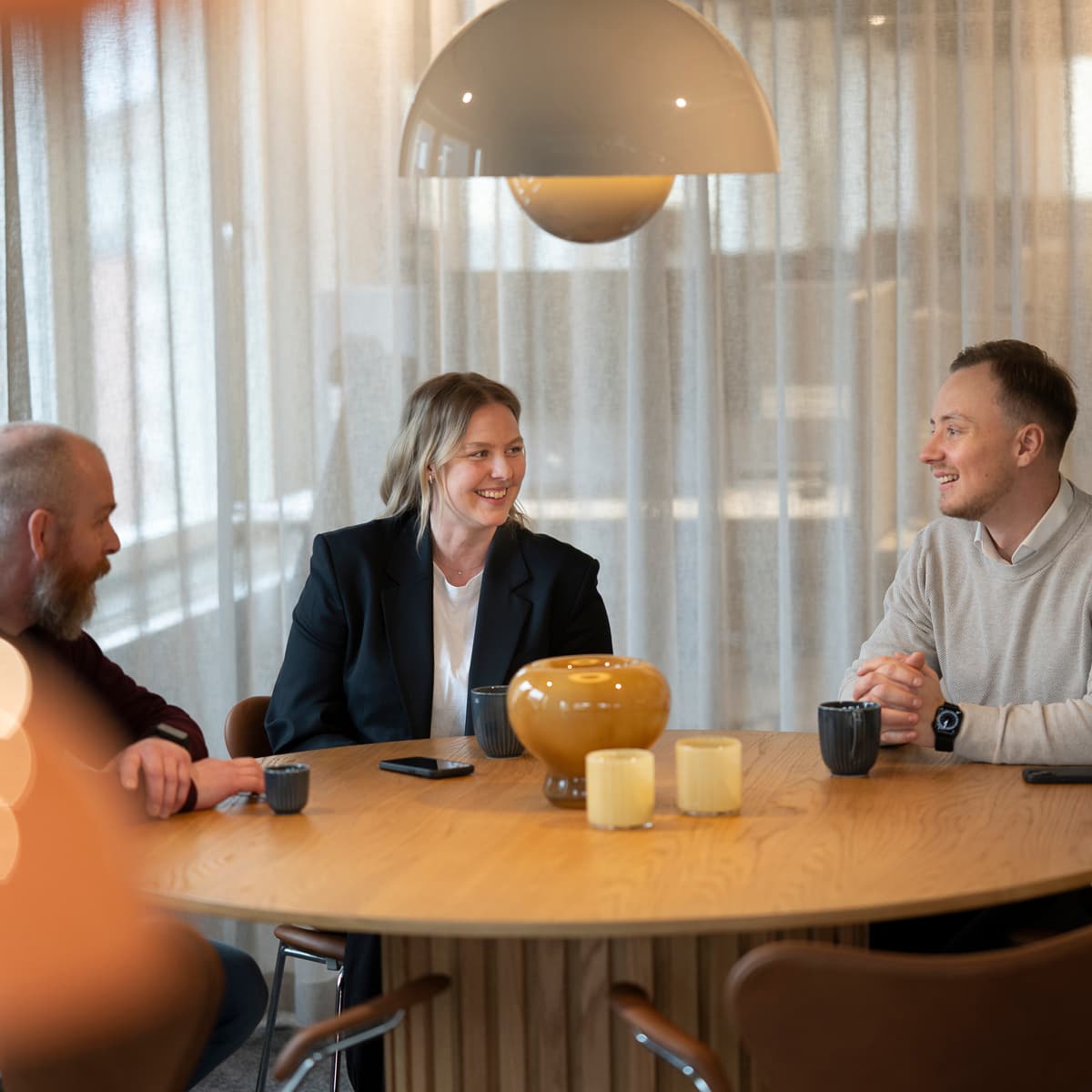 En grupp människor som sitter runt ett träbord.