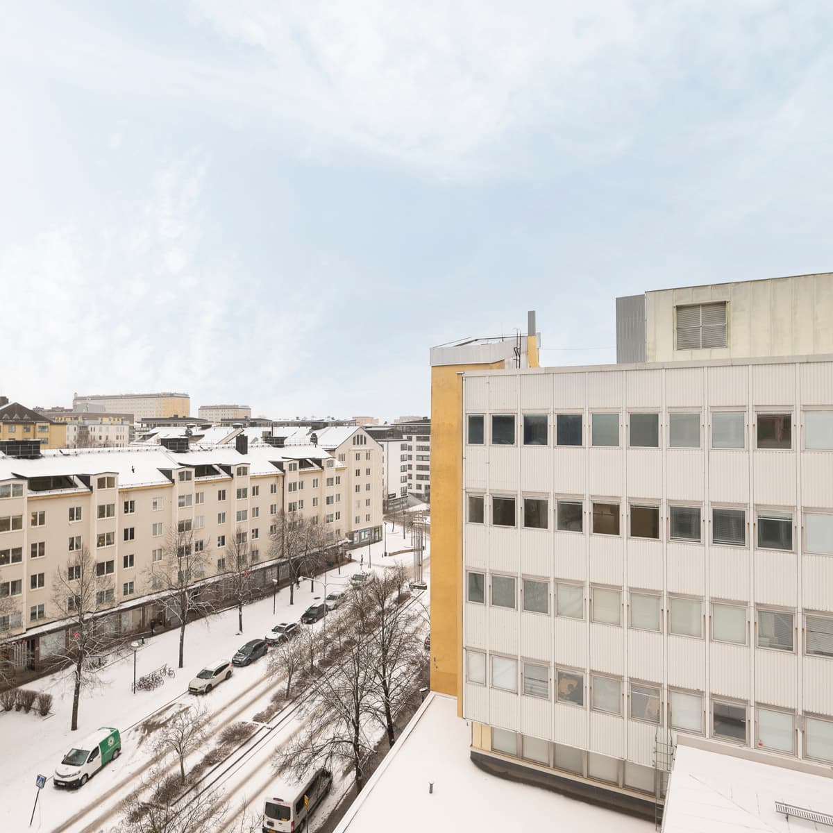 En utsikt över en snöig stad från ett fönster.