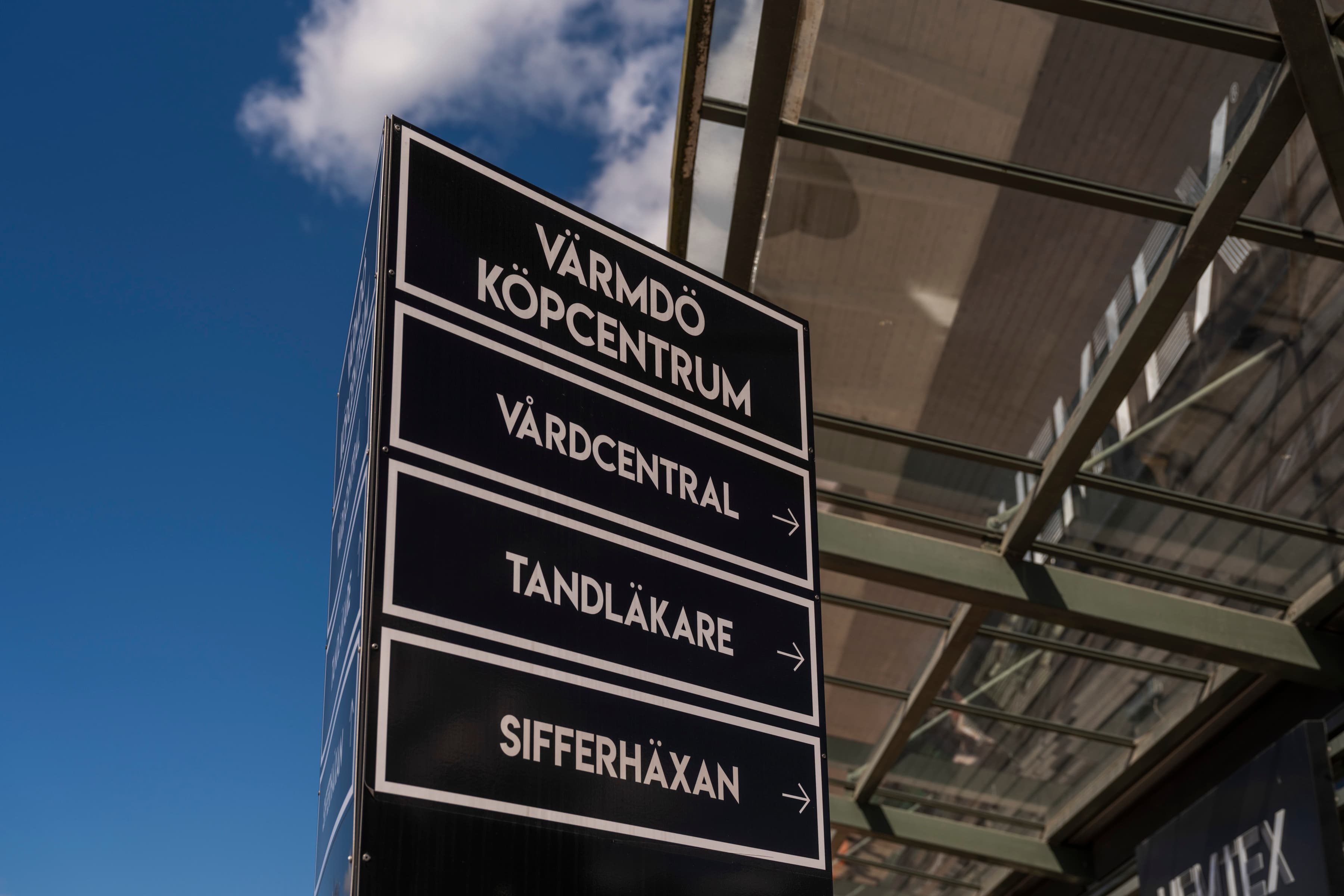 En svartvit skylt som står framför en byggnad.