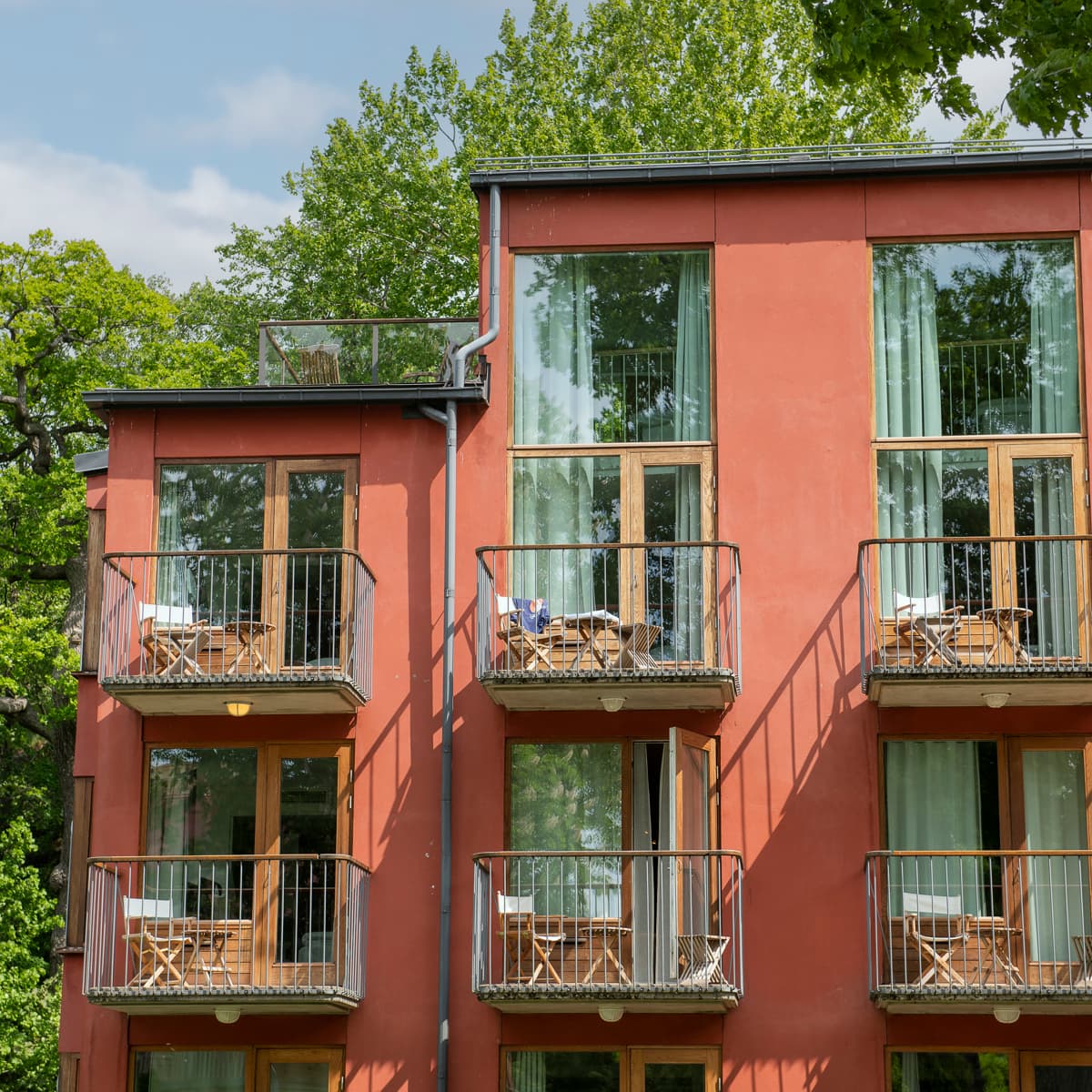 En röd byggnad med balkonger och balkonger på balkongerna.