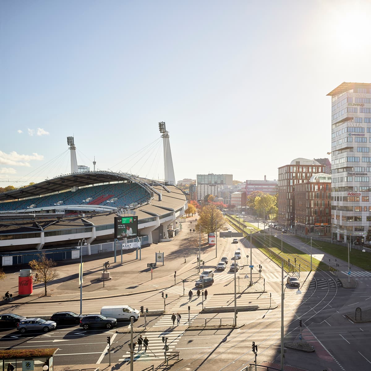 Solen skiner över en gata i en stad.