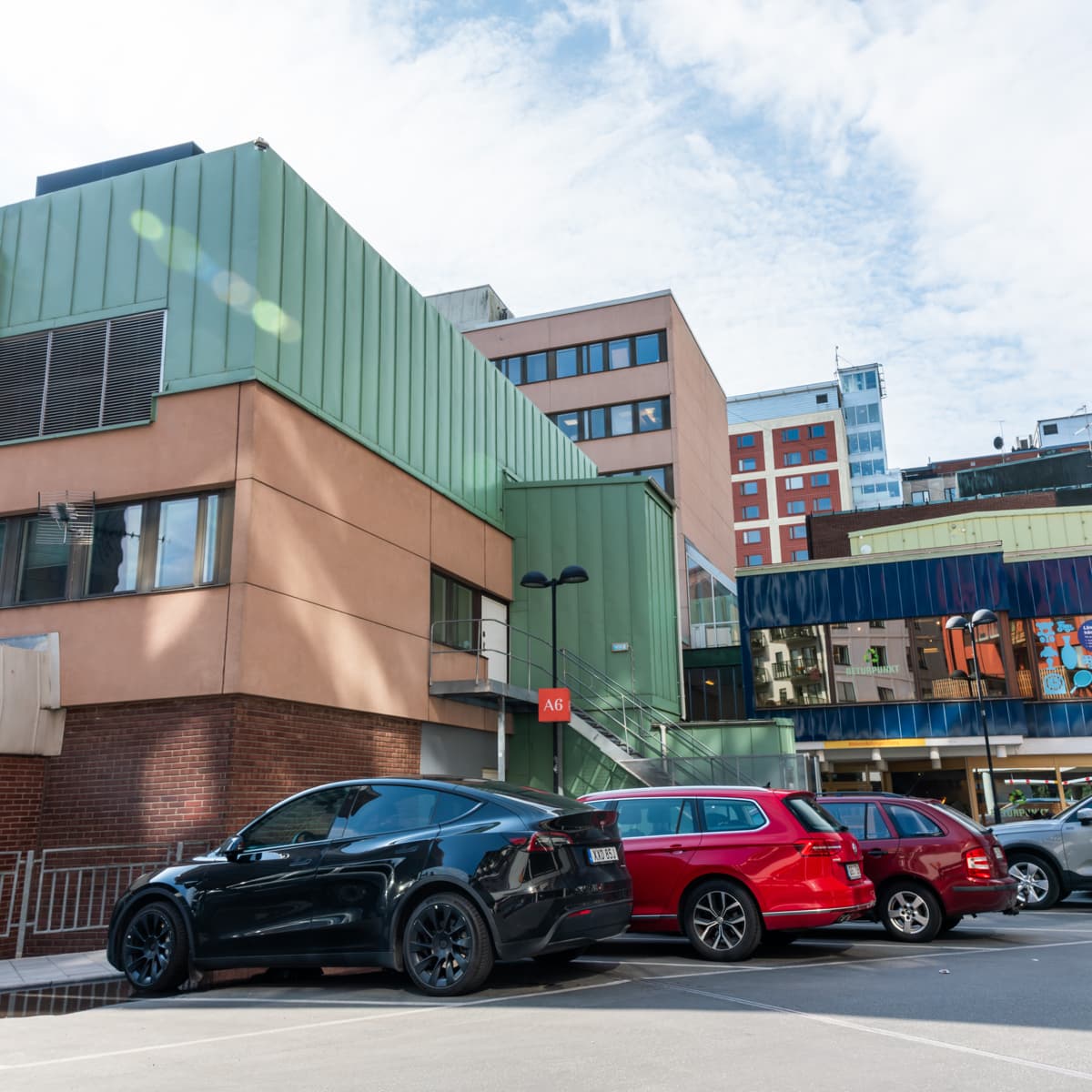 En grupp bilar parkerade framför en byggnad.