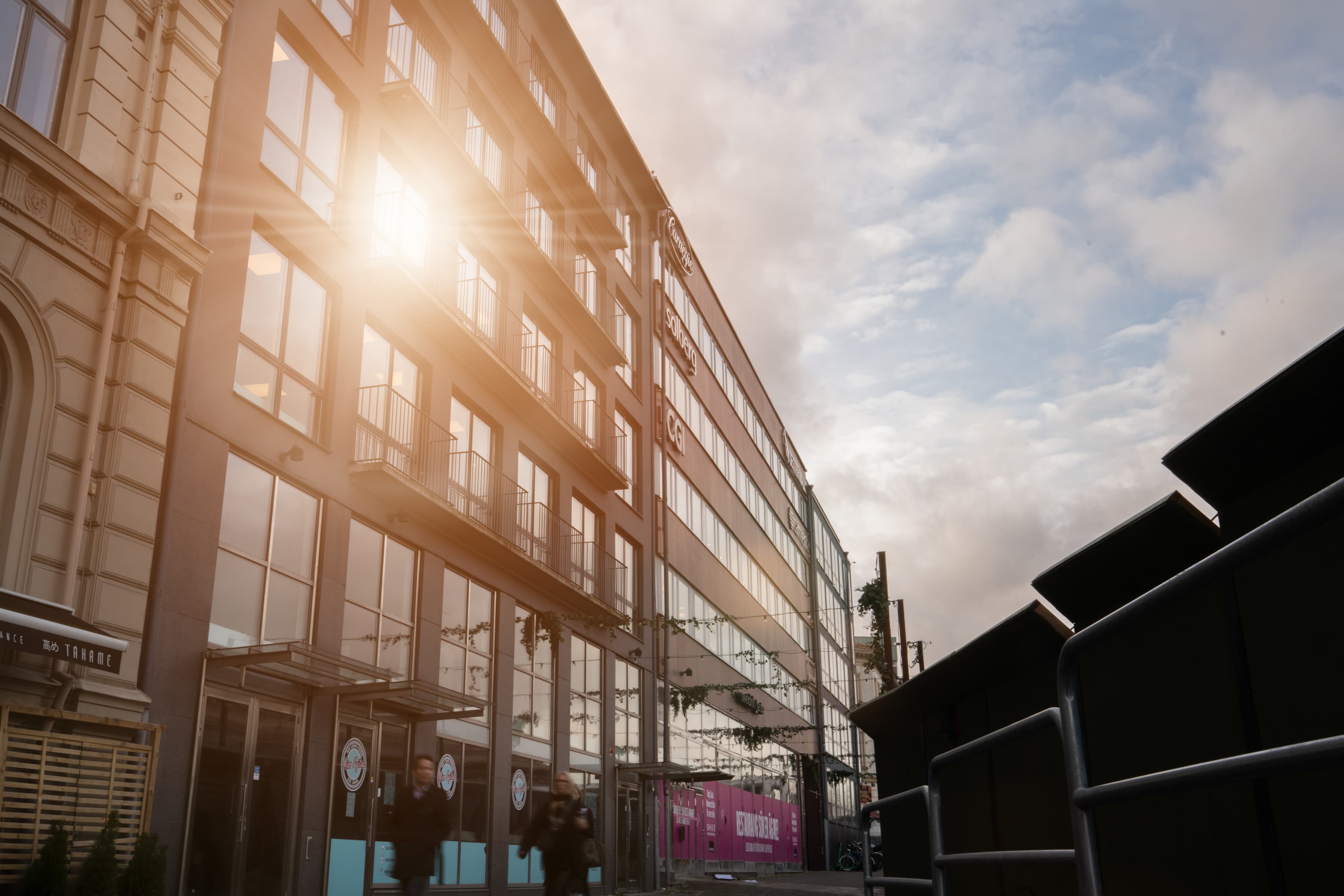 En man som går längs en gata bredvid en hög byggnad.