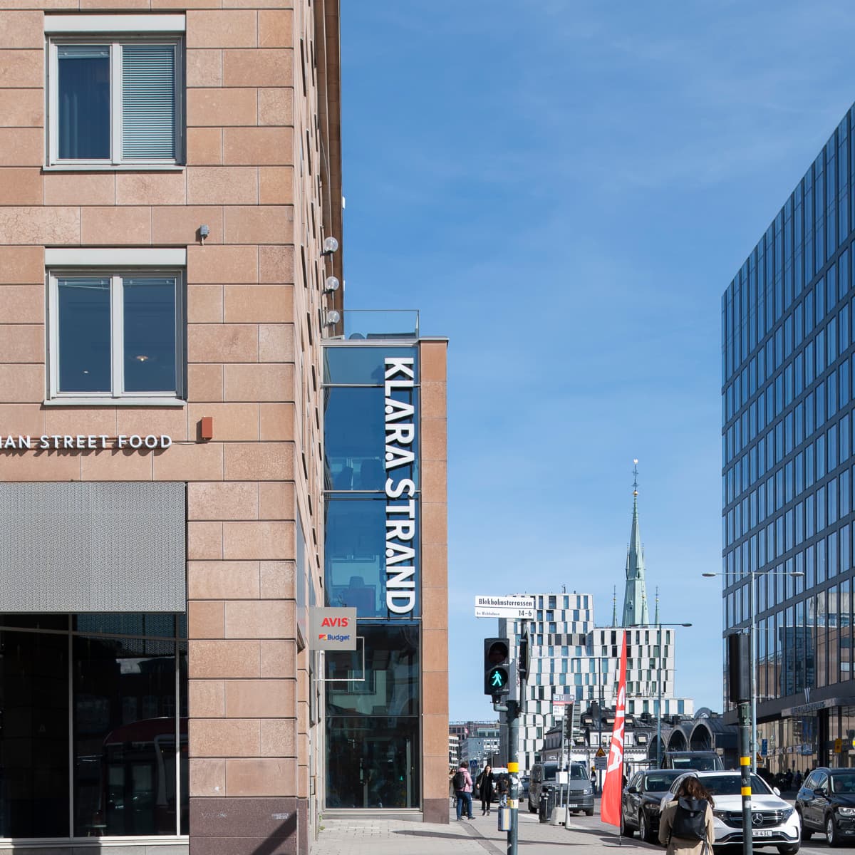 En hög tegelbyggnad som ligger bredvid ett trafikljus.