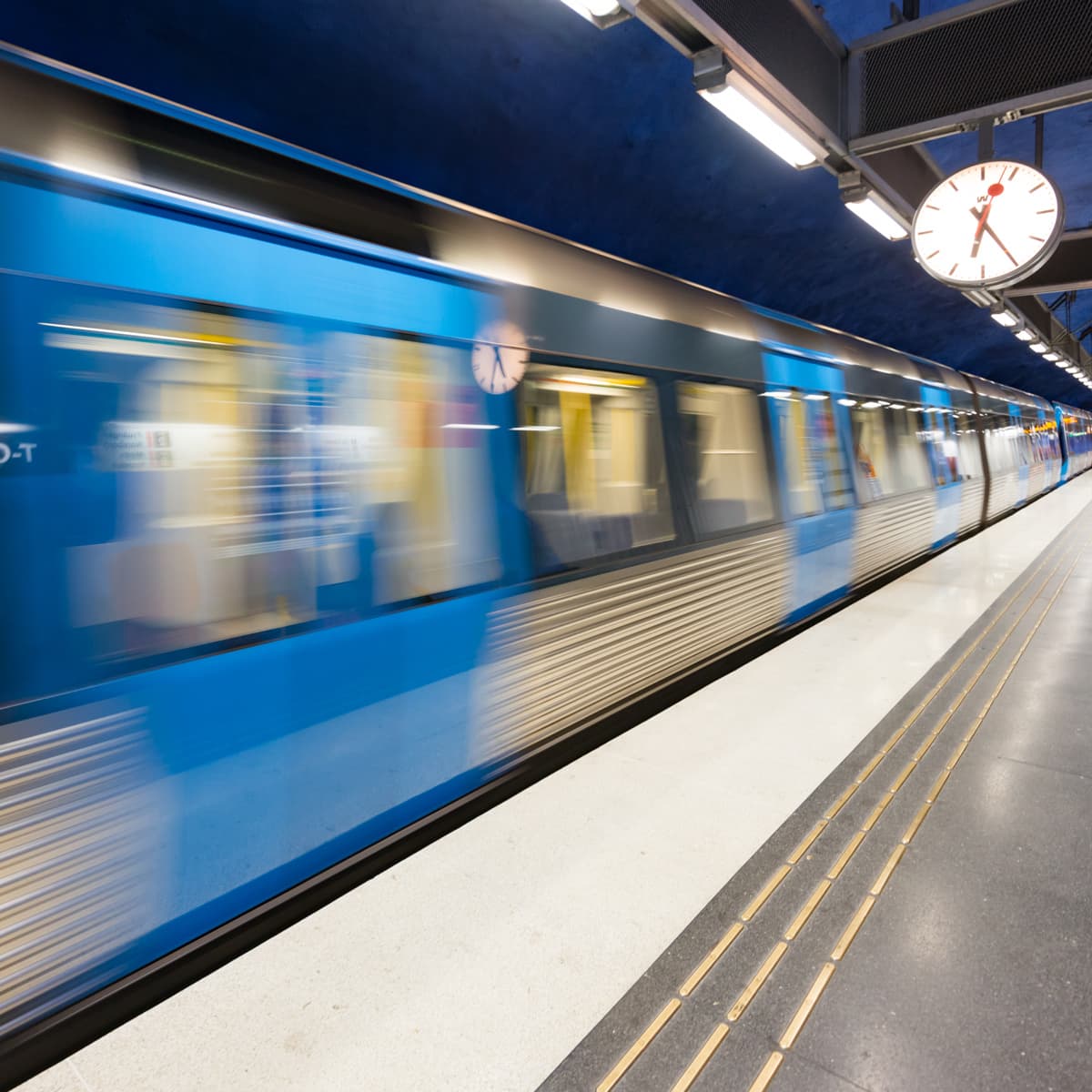 Ett suddigt foto av ett tåg som passerar förbi en plattform.