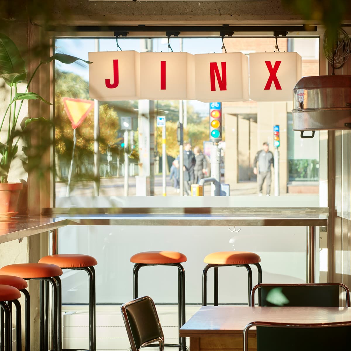 En restaurang med bord och stolar framför ett fönster.