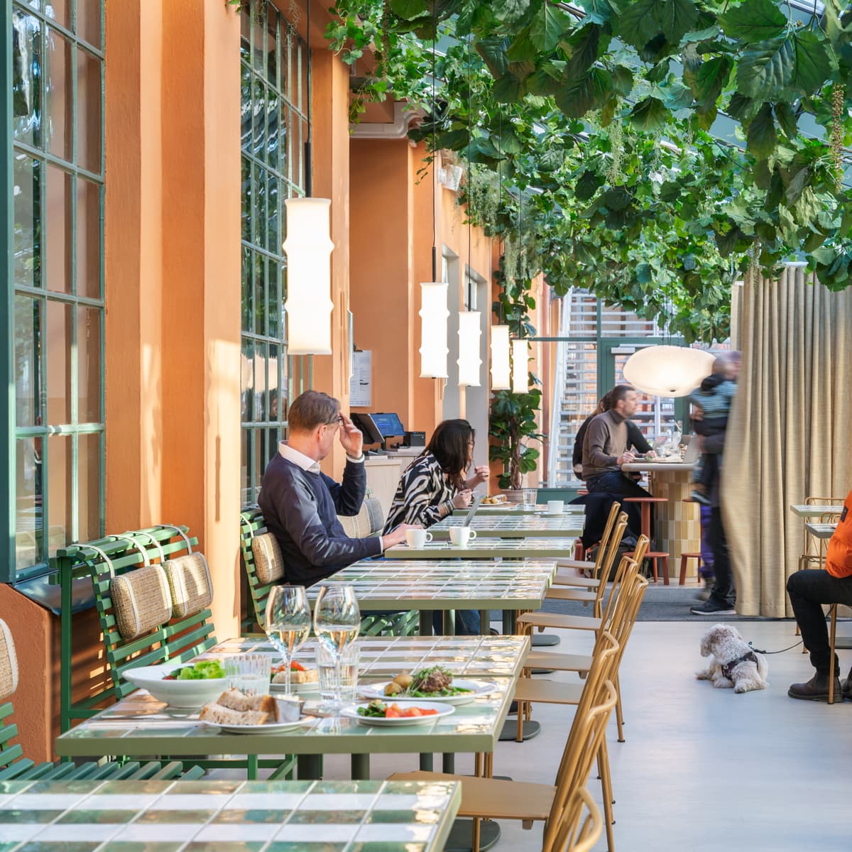 En grupp människor som sitter vid bord på en restaurang.