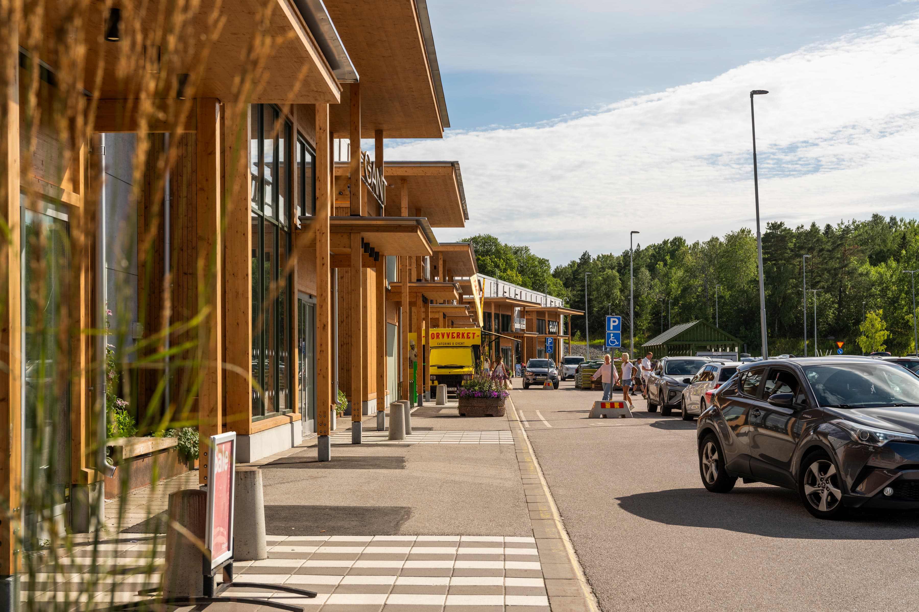 En bil som står parkerad vid sidan av vägen intill en byggnad.