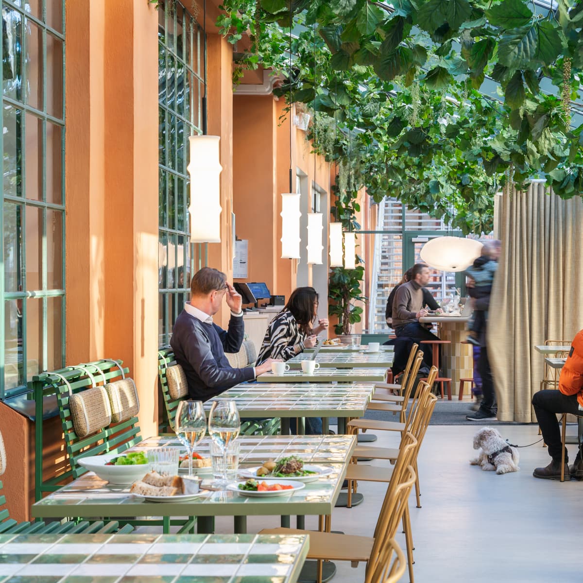 En grupp människor som sitter vid bord på en restaurang.