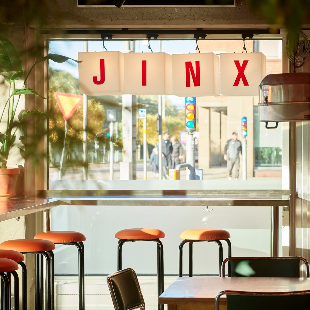 En restaurang med bord och stolar framför ett fönster.