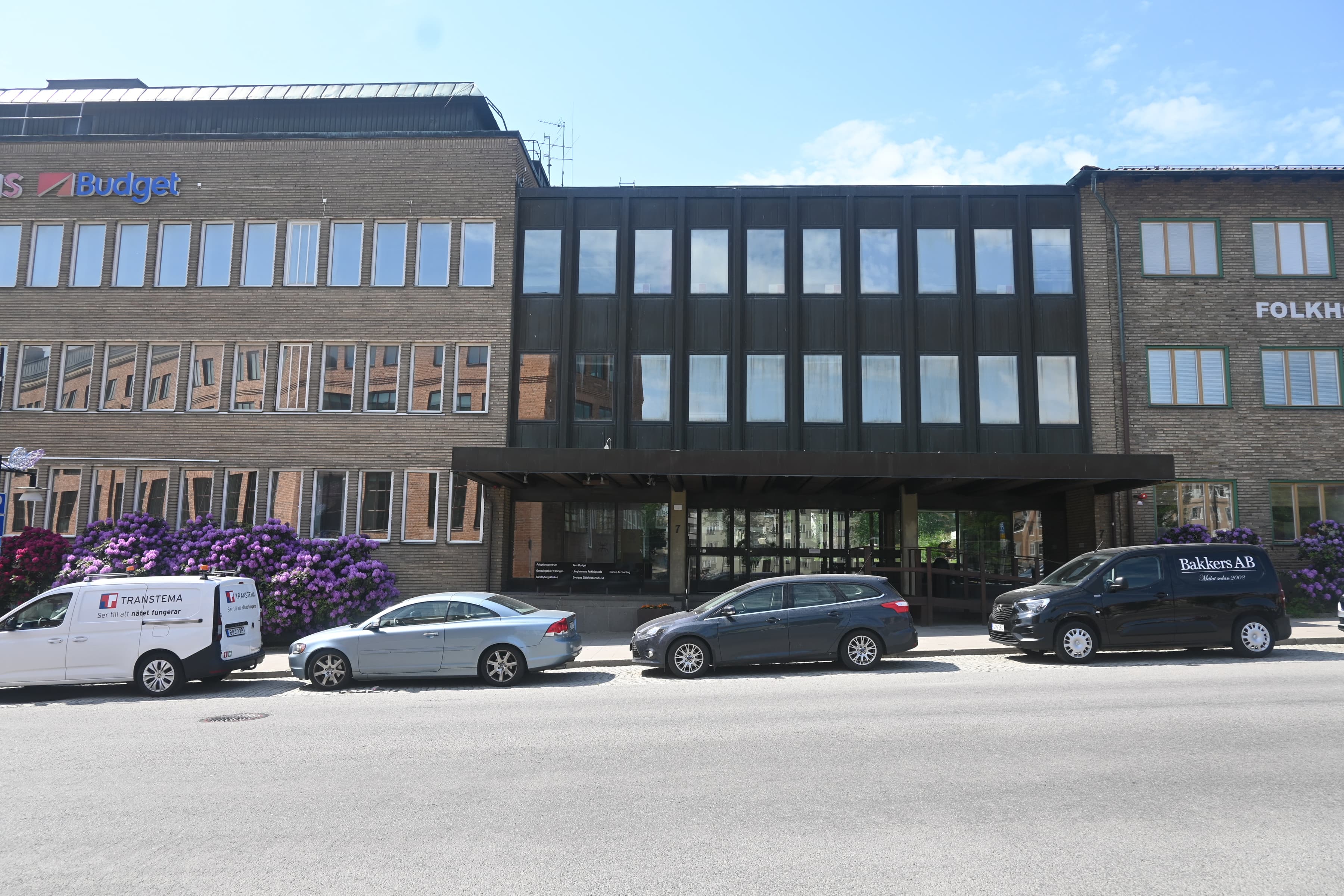 En grupp bilar parkerade framför en byggnad.