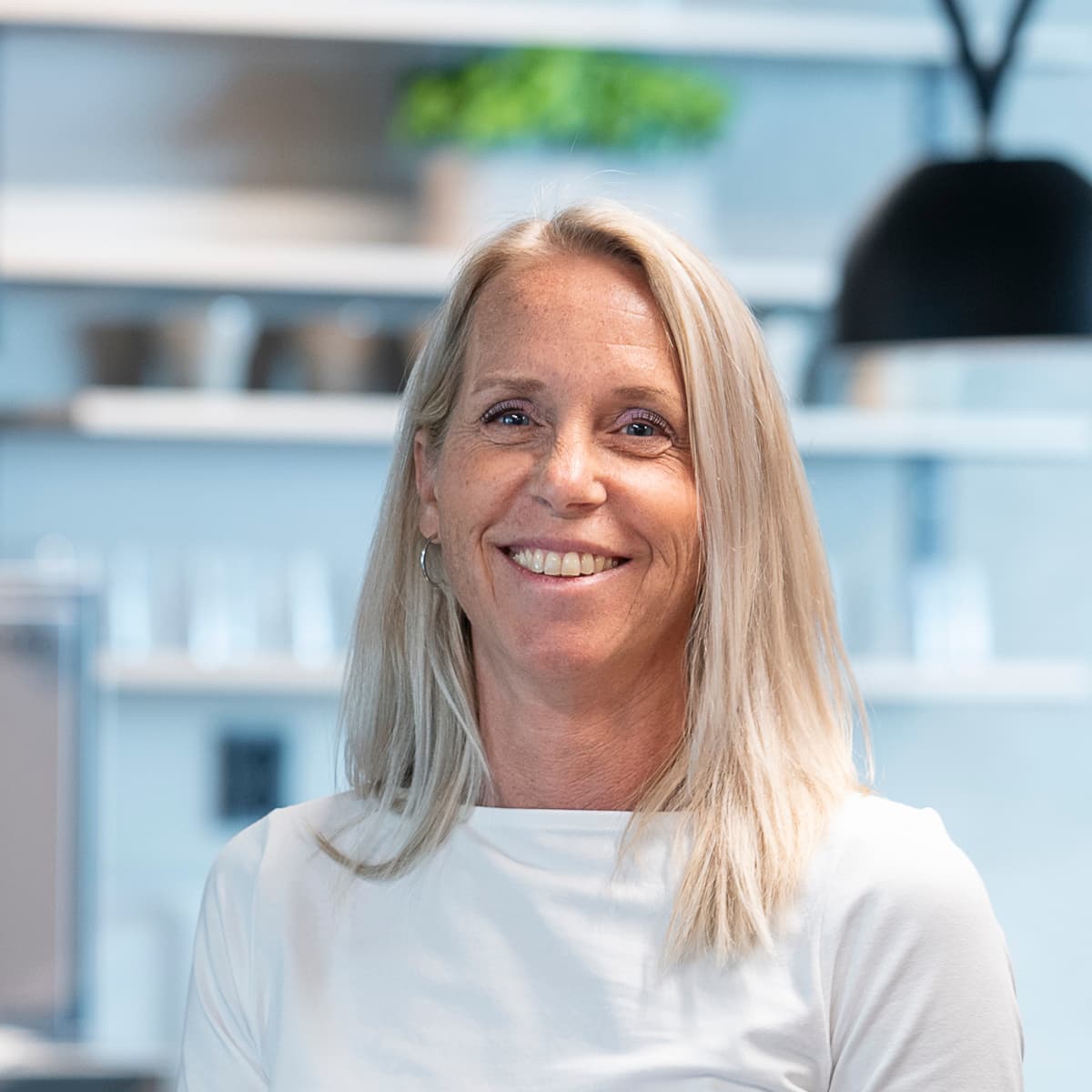 En kvinna sitter vid ett bord med en bärbar dator.