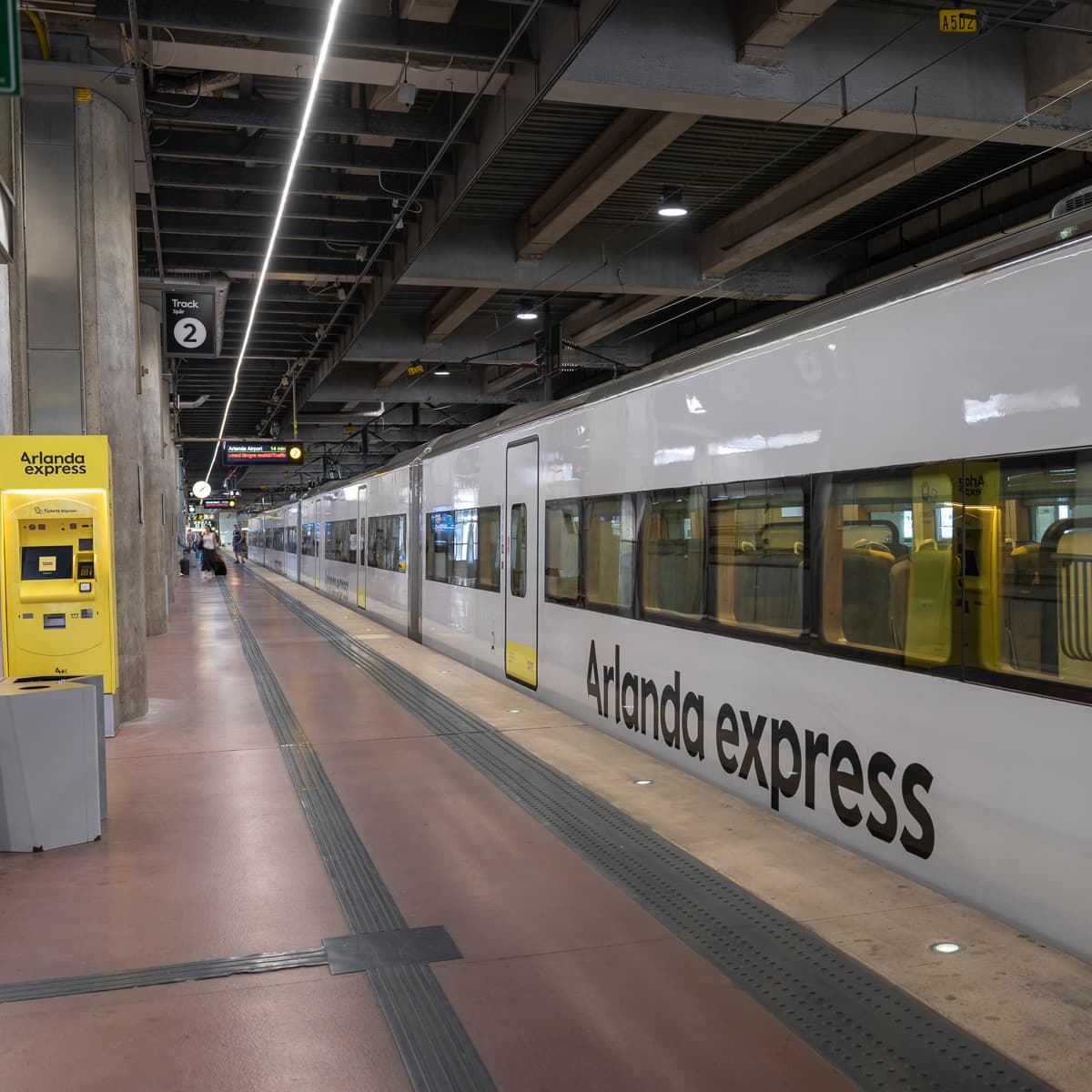 Ett tåg parkerat på en järnvägsstation bredvid en plattform.