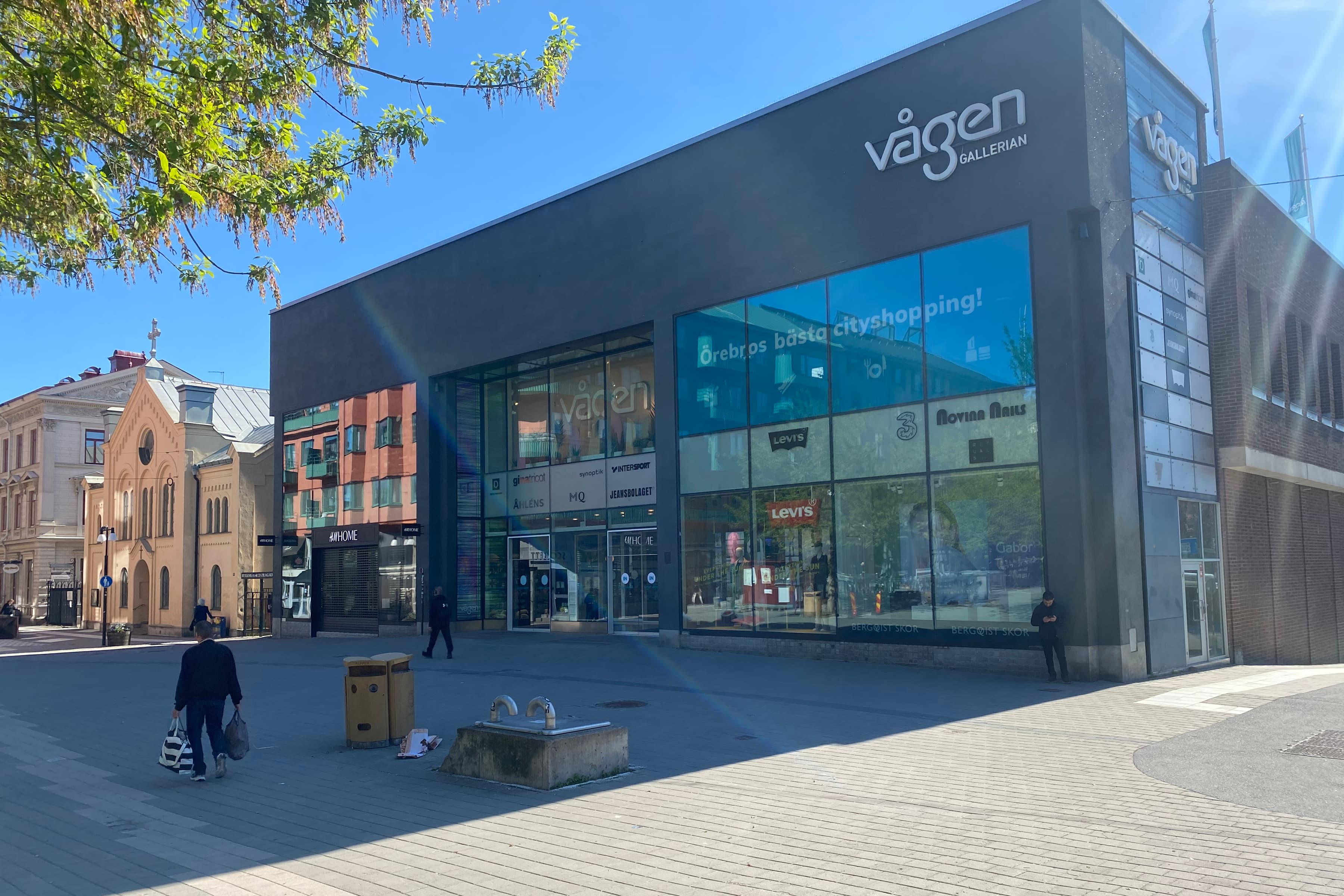 En man går förbi en byggnad på en gata i en stad.