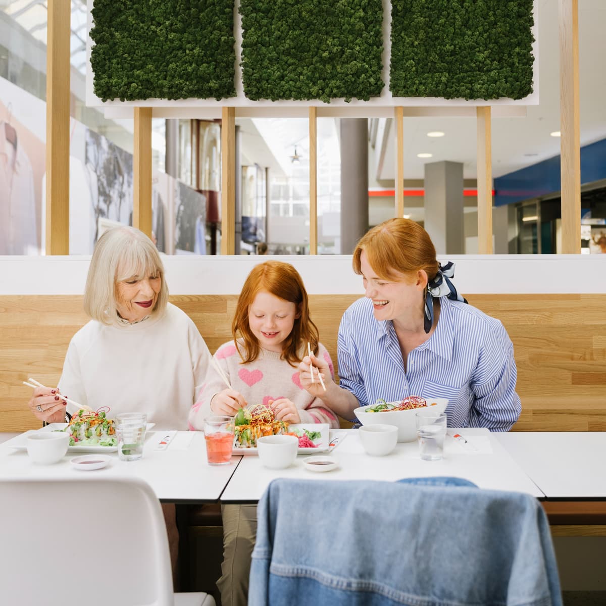 En grupp människor som sitter vid ett bord och äter mat.