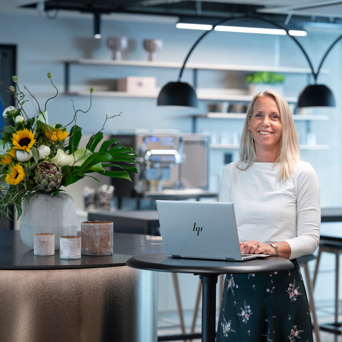 En kvinna sitter vid ett bord med en bärbar dator.