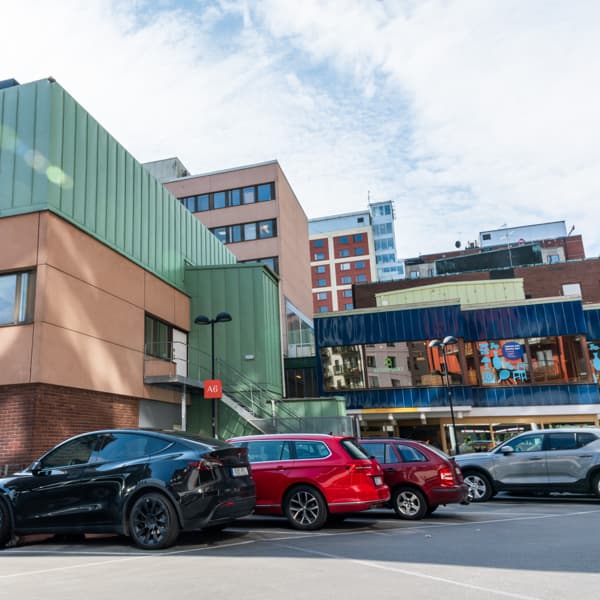 En grupp bilar parkerade framför en byggnad.