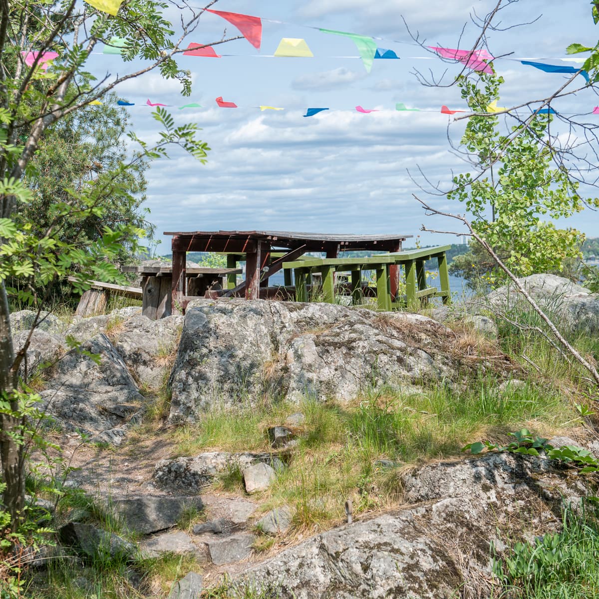 En träkonstruktion som sitter på toppen av en grönskande sluttning.