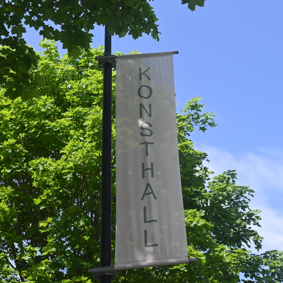 En skylt som hänger på sidan av en byggnad.