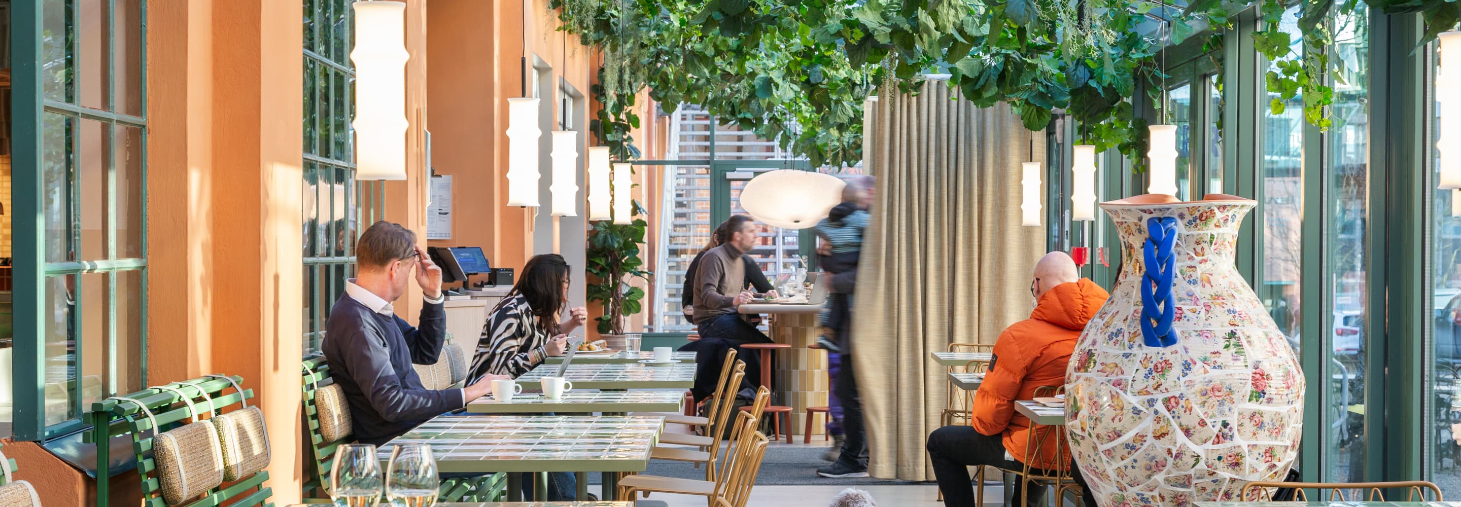 En grupp människor som sitter vid bord på en restaurang.