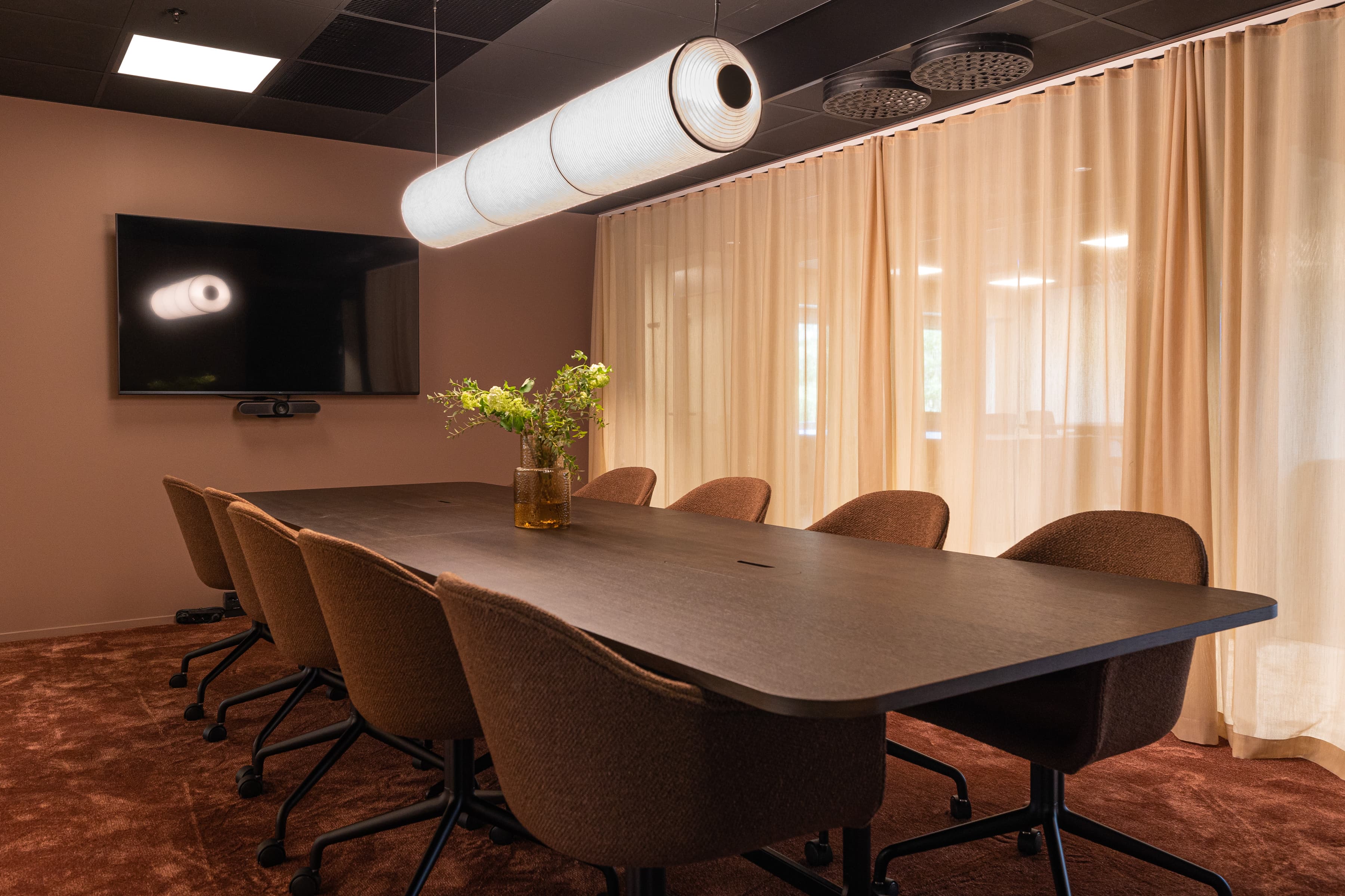 Ett konferensrum med ett långt bord och stolar.