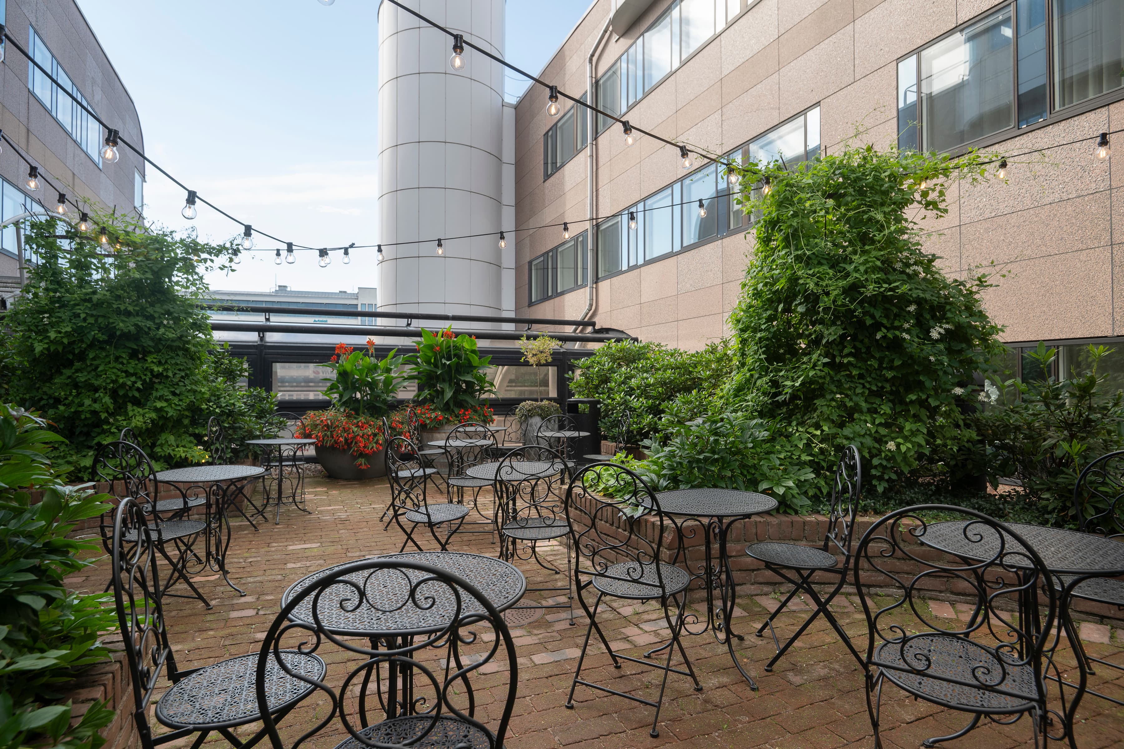 En innergård med bord och stolar och växter.