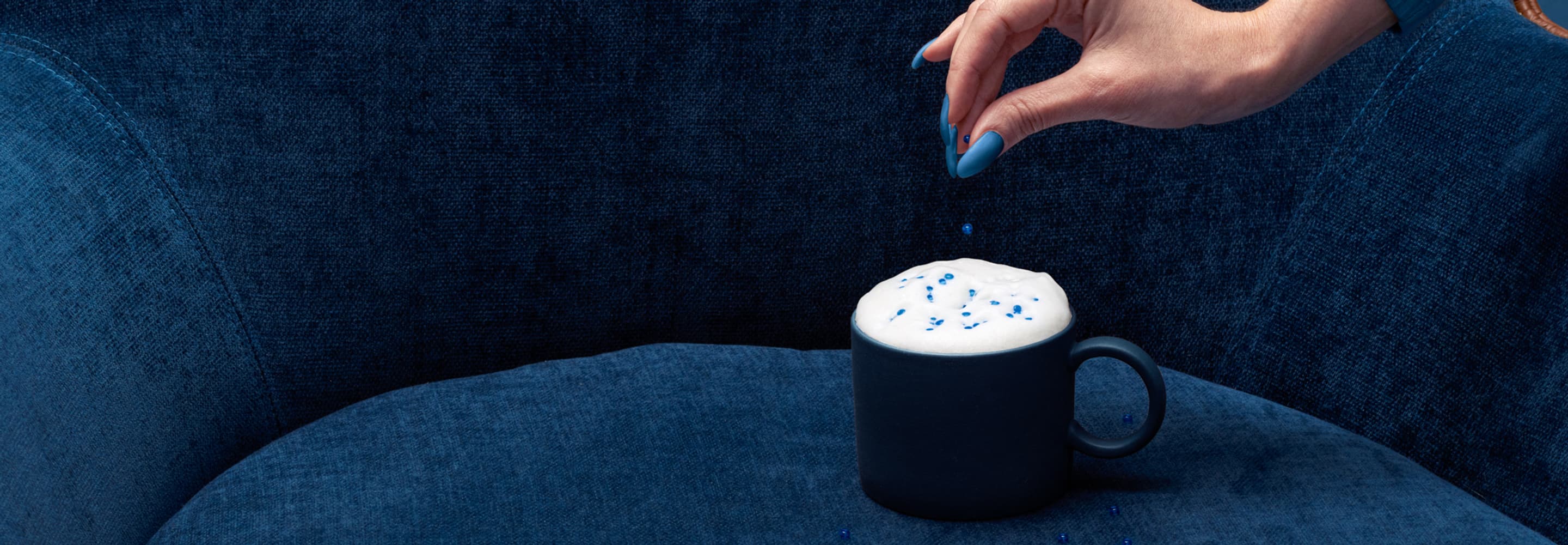 En person håller i en kopp med något i.