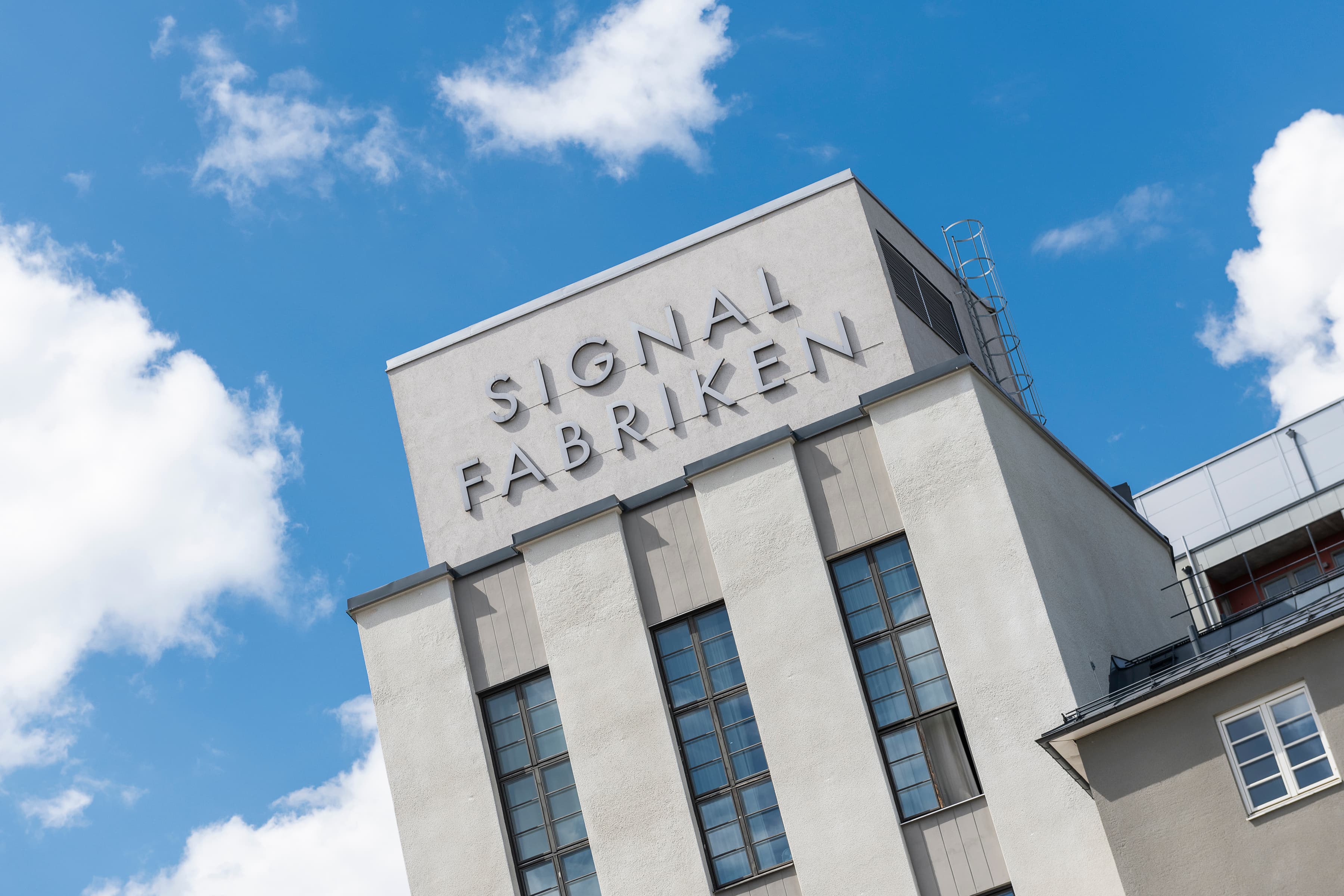 En hög byggnad med en skylt på toppen av den.