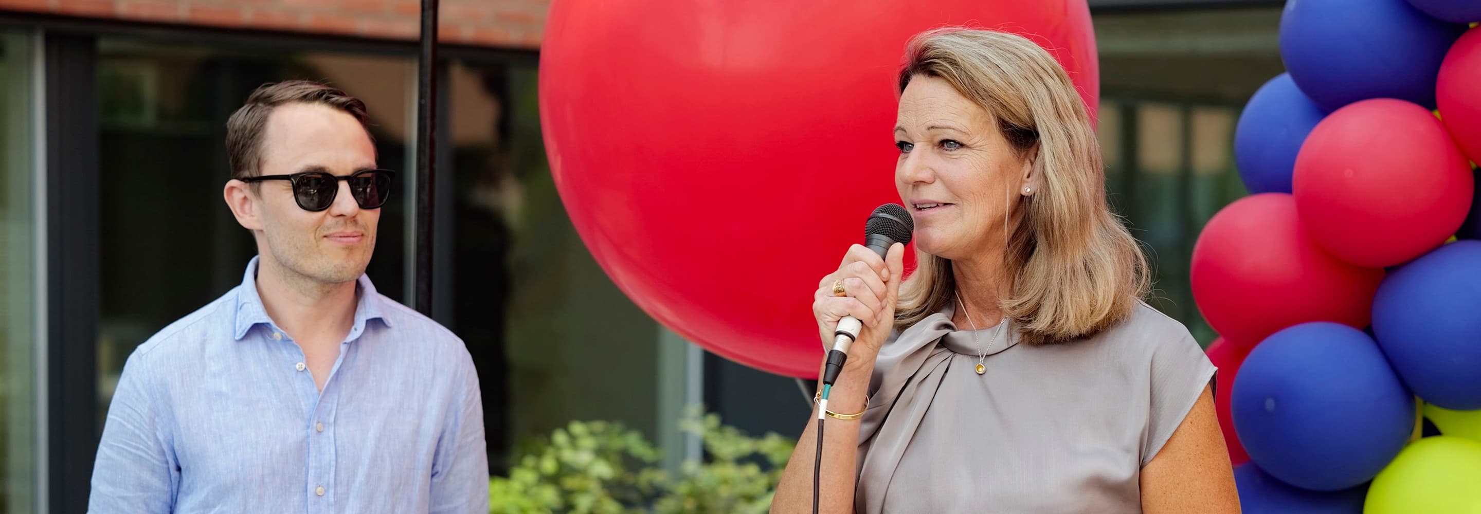 En man står bredvid en kvinna som håller i en mikrofon.
