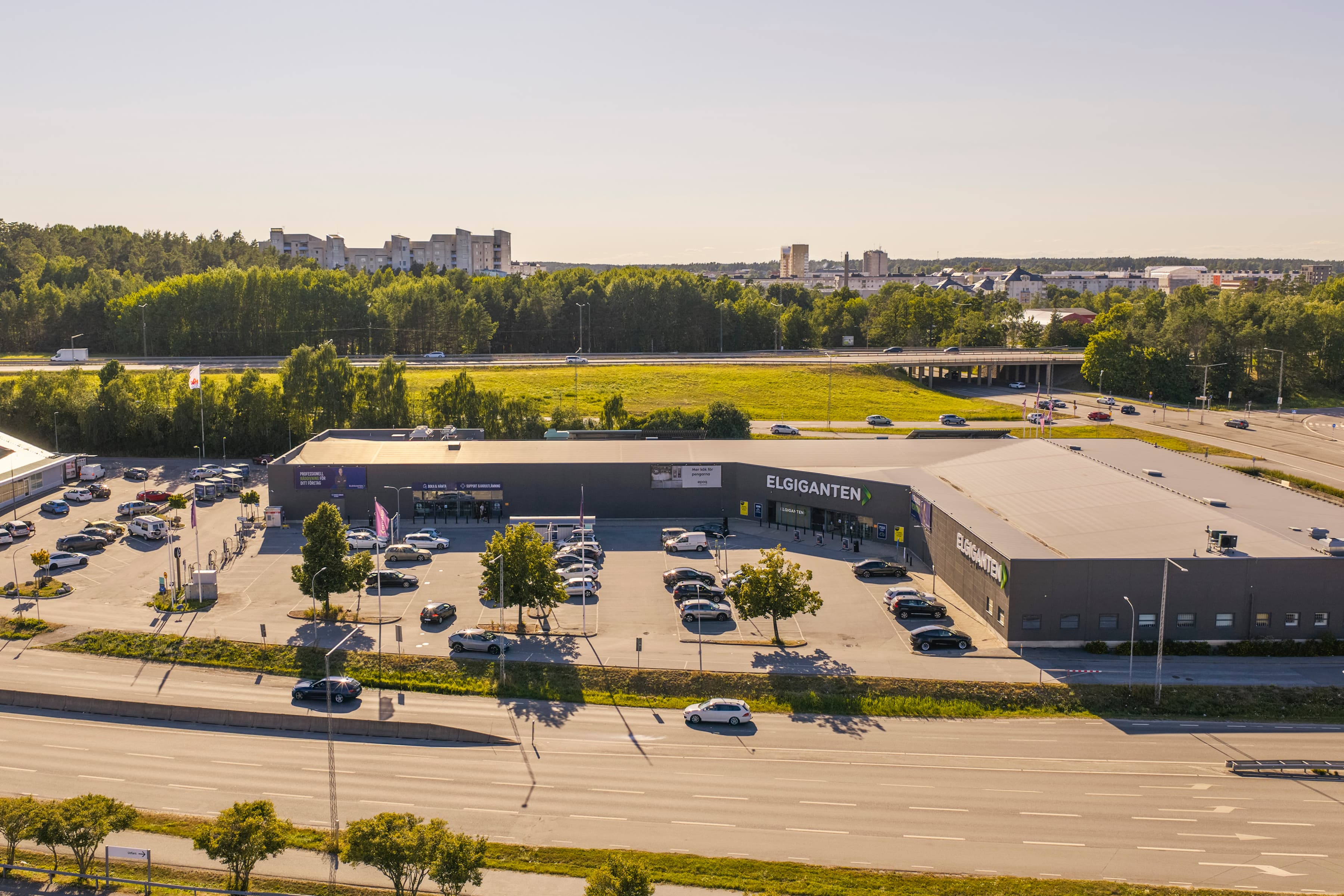 En flygbild över en parkeringsplats med en stor byggnad i bakgrunden.