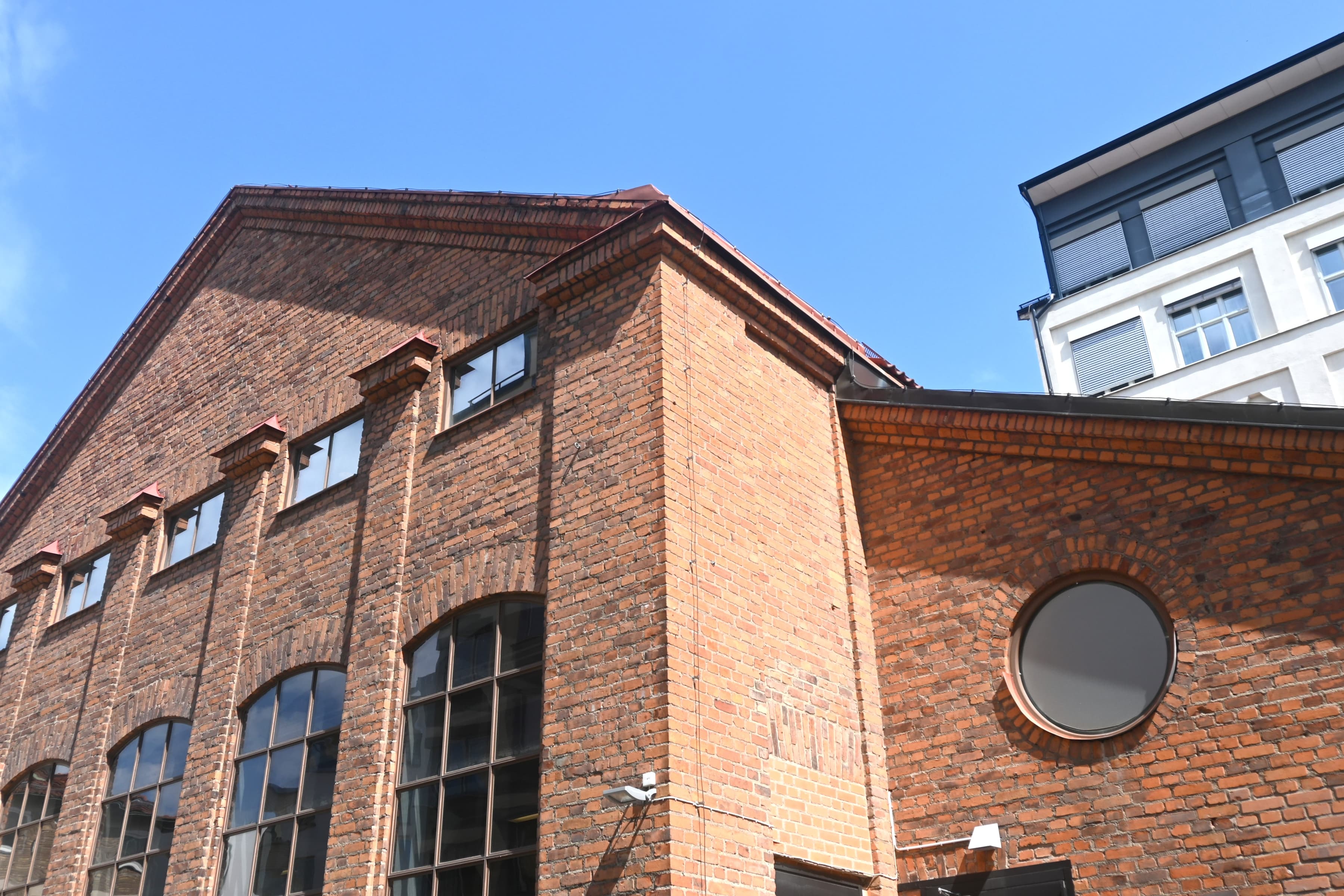En tegelbyggnad med runda fönster på en solig dag.